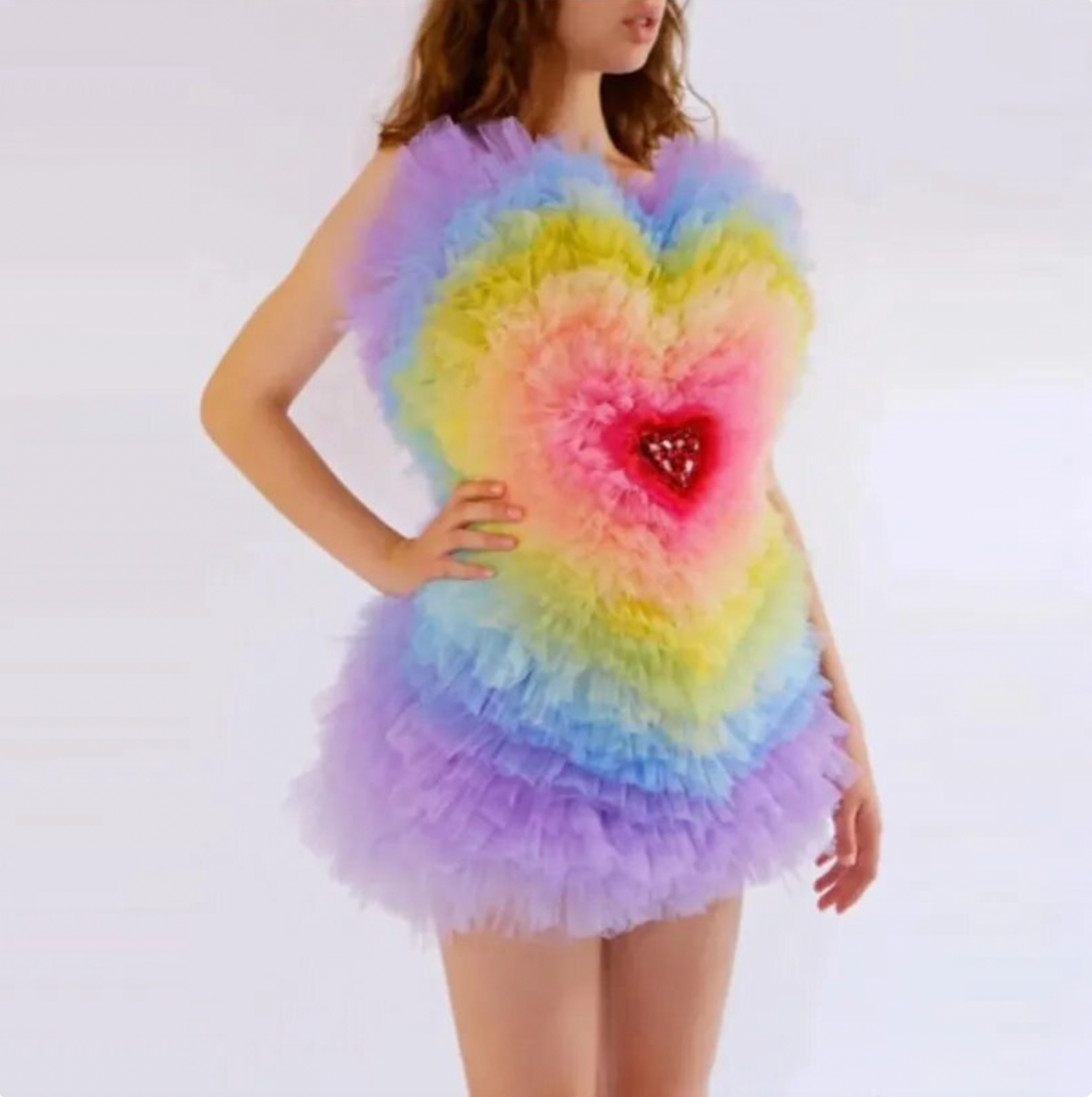 Add a touch of color and vibrancy to your wardrobe with our Rainbow Heart Dress Eureka. Featuring an off-shoulder design and layered tulle fabric, this mini dress is perfect for birthday celebrations and photoshoots. Embrace your playful side with this puffy and colorful dress.