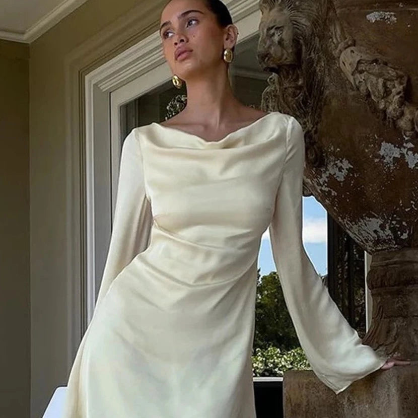 Introducing the Robe Shona - a must-have for the sophisticated and exclusive woman. Made of luxurious satin, this sexy yellow dress drapes effortlessly for a loose yet flattering fit. With a bodycon silhouette, O-neckline, and long sleeves, it exudes understated elegance. Perfect for a night out or a special occasion.