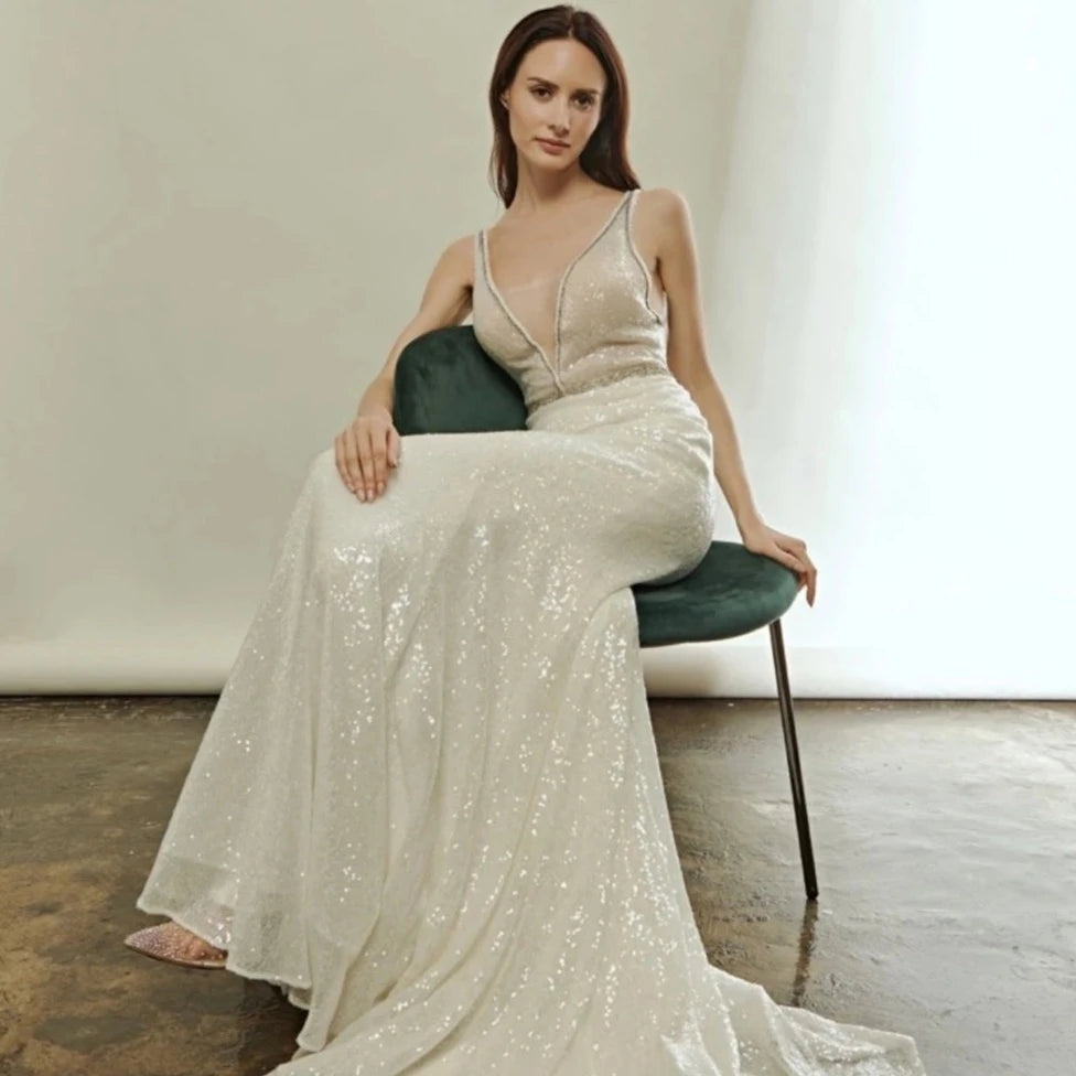 Indulge in the luxurious allure of the Robe Ivonne. This stunning wedding dress features a sexy deep V-neck and a backless design, perfect for showcasing your curves. Embellished with sparkly sequins, this robe exudes elegance and grace. Slip into this mermaid style gown and feel like a glamorous bride on your special day.