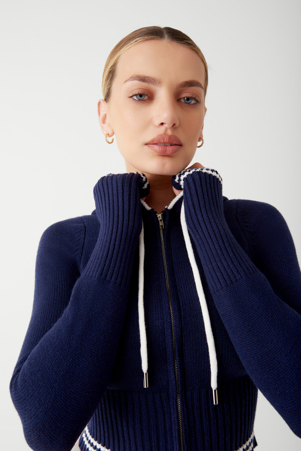 Elevate your loungewear with the Aimee Cloud Knit Zip Up Hoodie by Frankies Bikinis. Made with ultra-soft knit fabric, ribbed cuffs and waist, and a zip-up front, the Aimee hoodie combines comfort and style effortlessly. Pair it with the matching Fleur pant for the ultimate cozy and chic outfit.