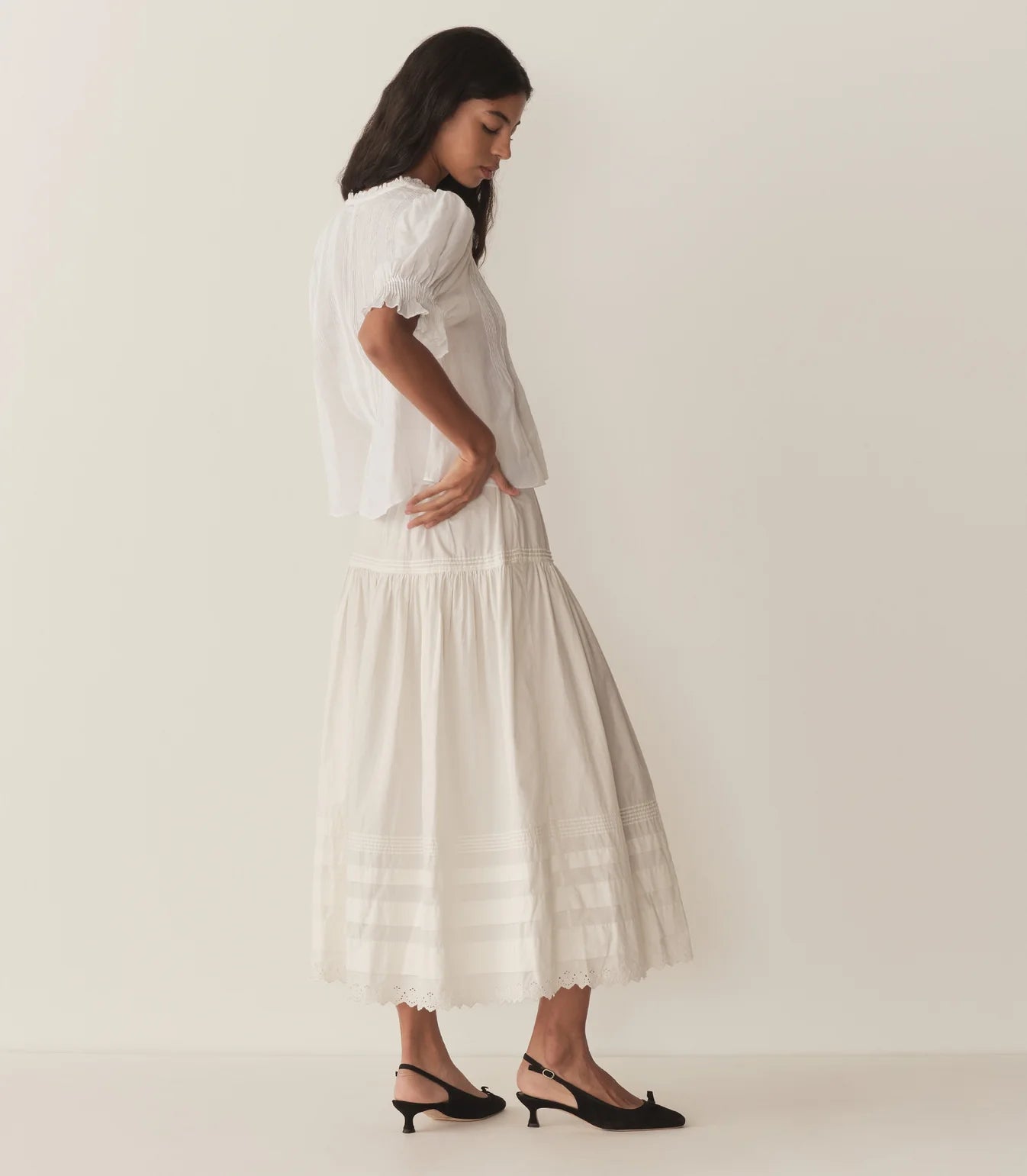 Experience timeless elegance with the Karlie Top, crafted from lightweight ramie for a delicate, airy feel. Its plunging V-neckline framed by soft ruffles and intricate pintuck detailing adds a touch of vintage charm. The starburst button line down the front enhances its refined look, while short puffed sleeves bring a playful silhouette. Perfect for wearing loose or tucked into high-waisted jeans, this versatile top effortlessly elevates any outfit with a graceful Edwardian-inspired style.