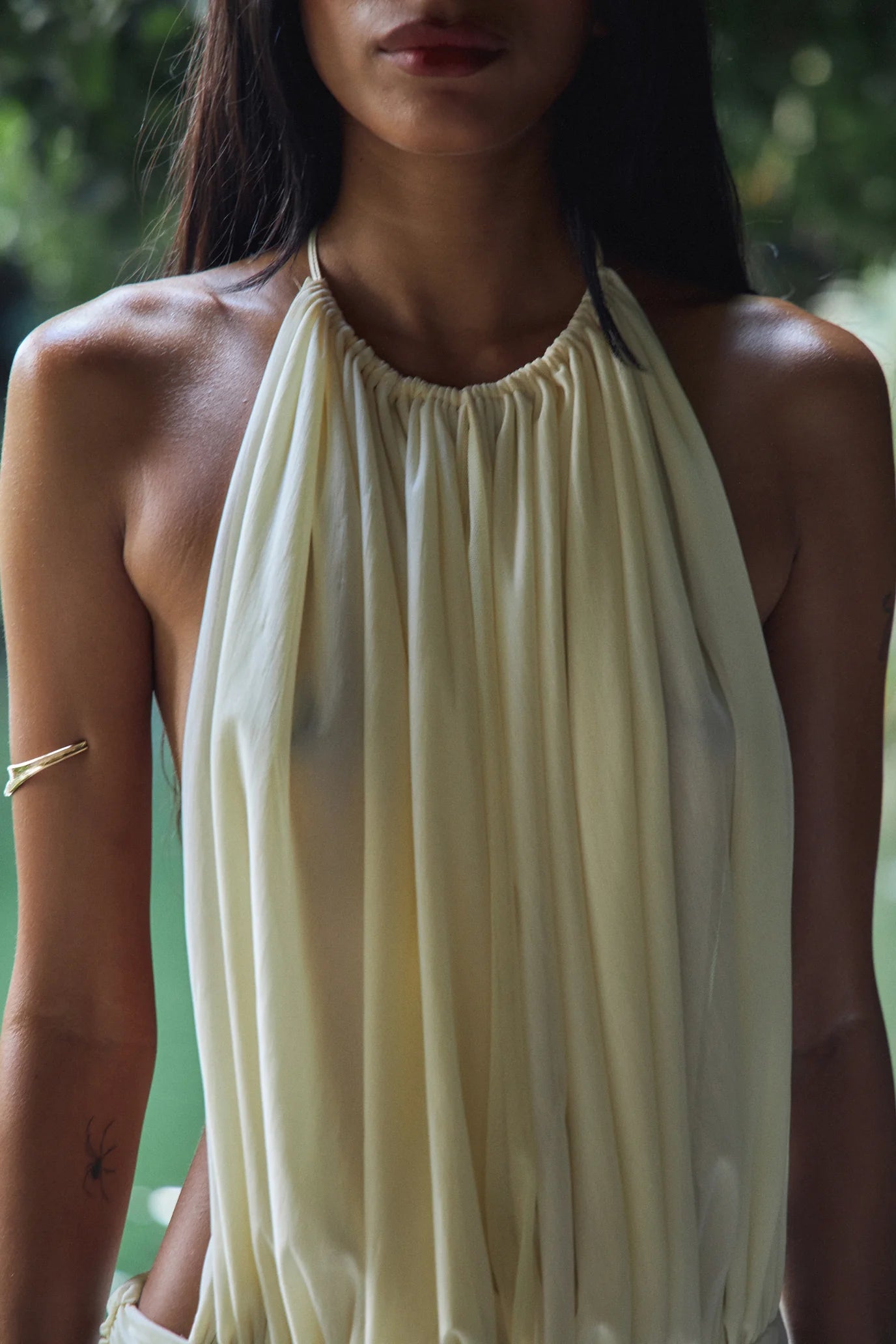 The La Piscine Mini Dress in Butter blends elegance with versatility. Its draped, ruched design and semi-sheer fabric create a delicate silhouette, while adjustable front panels ensure a perfect fit. The open back and hand-beaded hem add refined detail, and the unique ties can be styled as a halter or strapless, offering multiple chic looks for any occasion. Embrace effortless sophistication with this captivating mini dress.