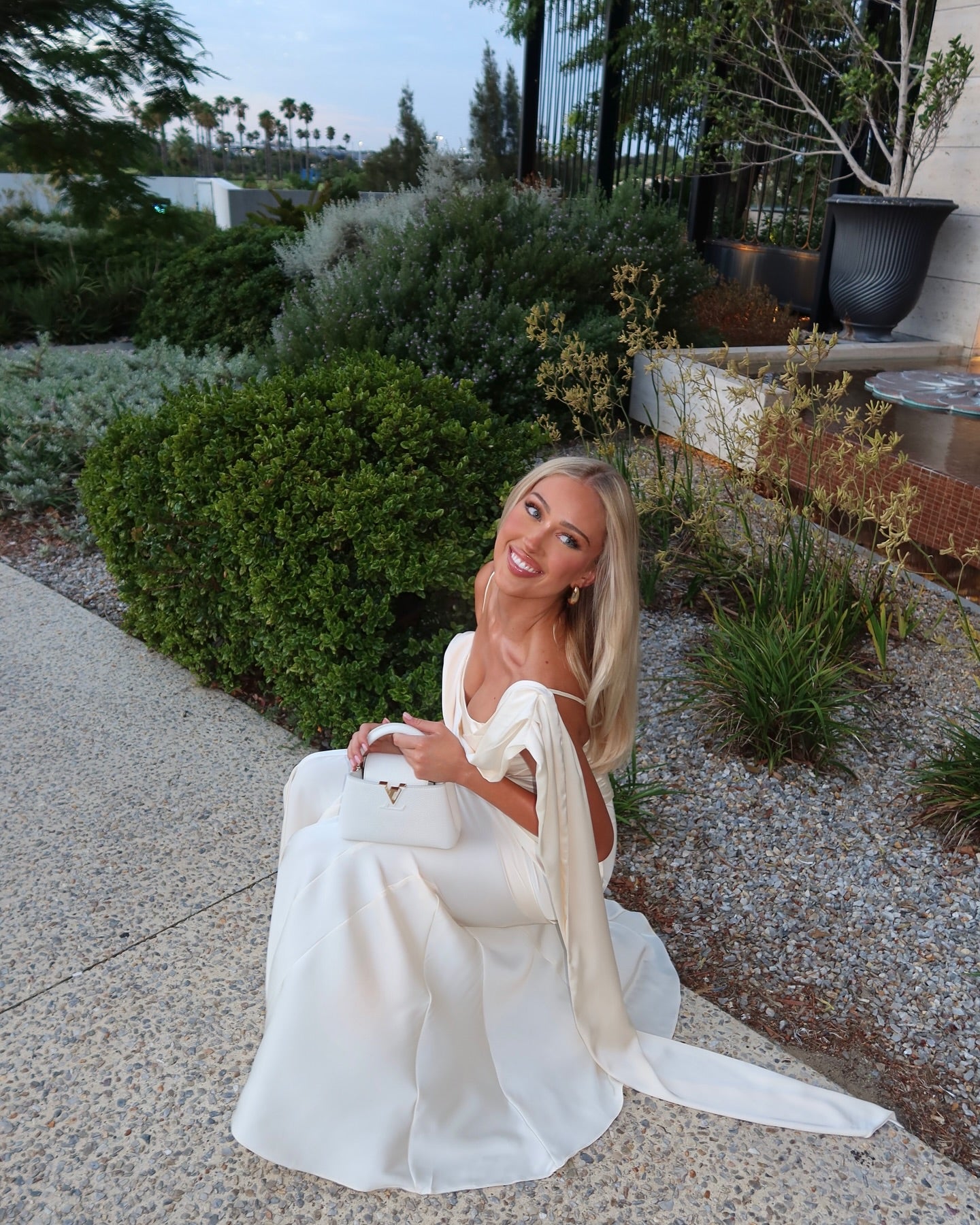 Elevate your elegance with the Celine Corset Gown, a luxurious satin masterpiece designed to flatter every figure. Featuring a corset waist that sculpts your silhouette and graceful draping at the hips, this gown enhances your natural curves. The asymmetric design highlights a delicate rosette on one shoulder and a flowing scarf on the other, adding a unique touch of sophistication. The slightly flared hemline completes this stunning look, perfect for making a memorable entrance at any special occasion.