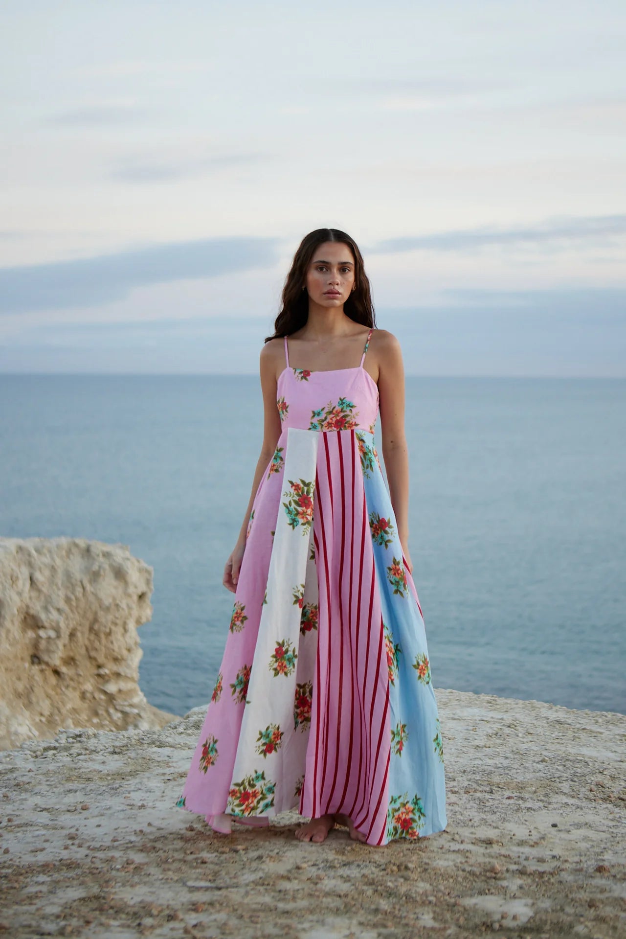 Introducing the Rue Dress - a vibrant patchwork maxi dress that blends soft florals and striking stripes for a unique and joyful look. The light, airy fabric and delicate spaghetti straps make it perfect for summer adventures, while the playful yet sophisticated mix of prints adds elegance to any occasion. Make a statement with effortless style.