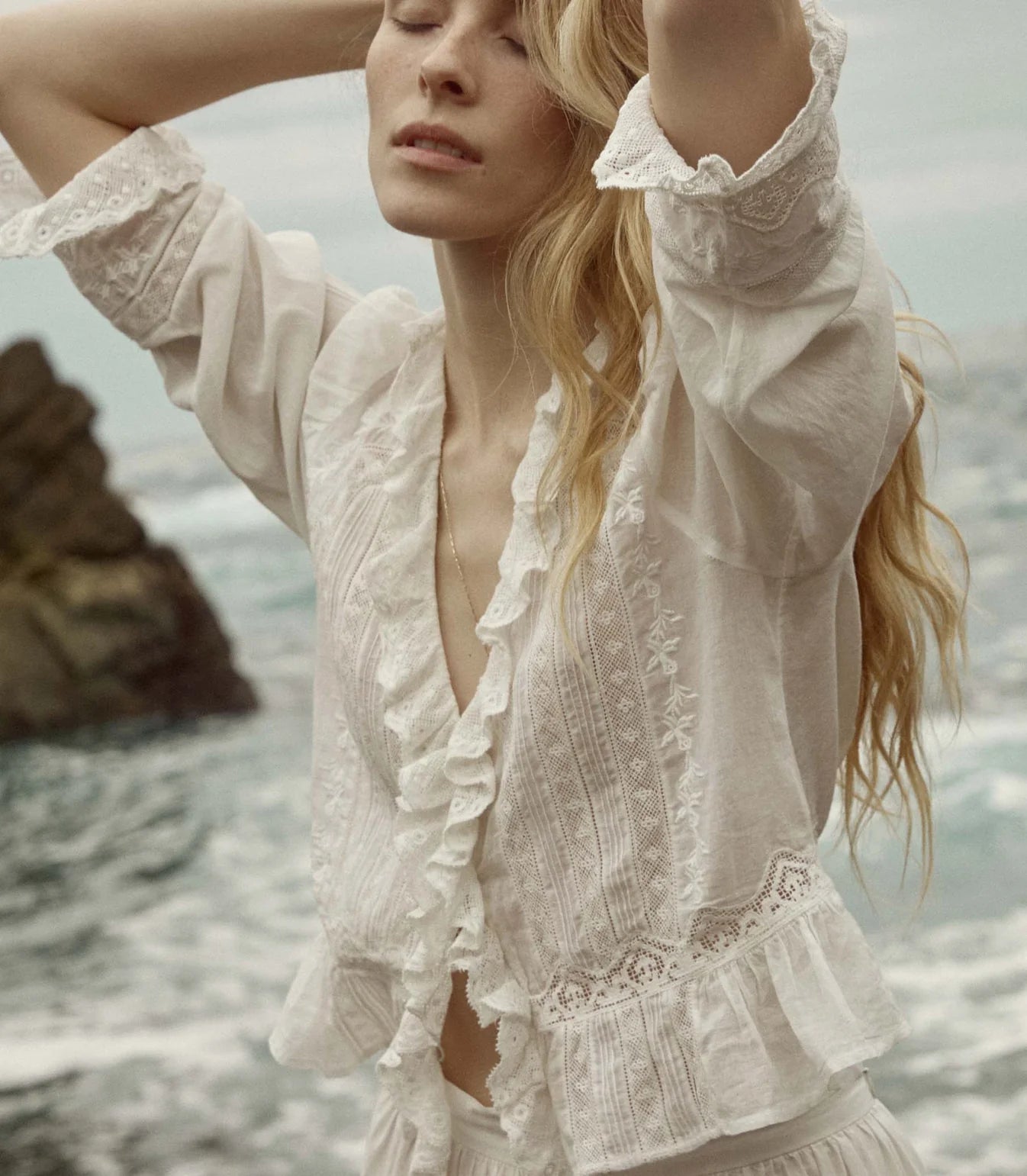 Crafted from the softest organic cotton voile, the Victorian-inspired Eldoris Top features a plunging V-neckline framed with cascading lace-trimmed ruffles that extend down the bodice and alternating panels of inset lace, clustered pintucks, and intricate embroidery at the yoke and back. A line of delicate buttons run down the front, while a cinched and slightly cropped waist finishes in a subtle peplum.