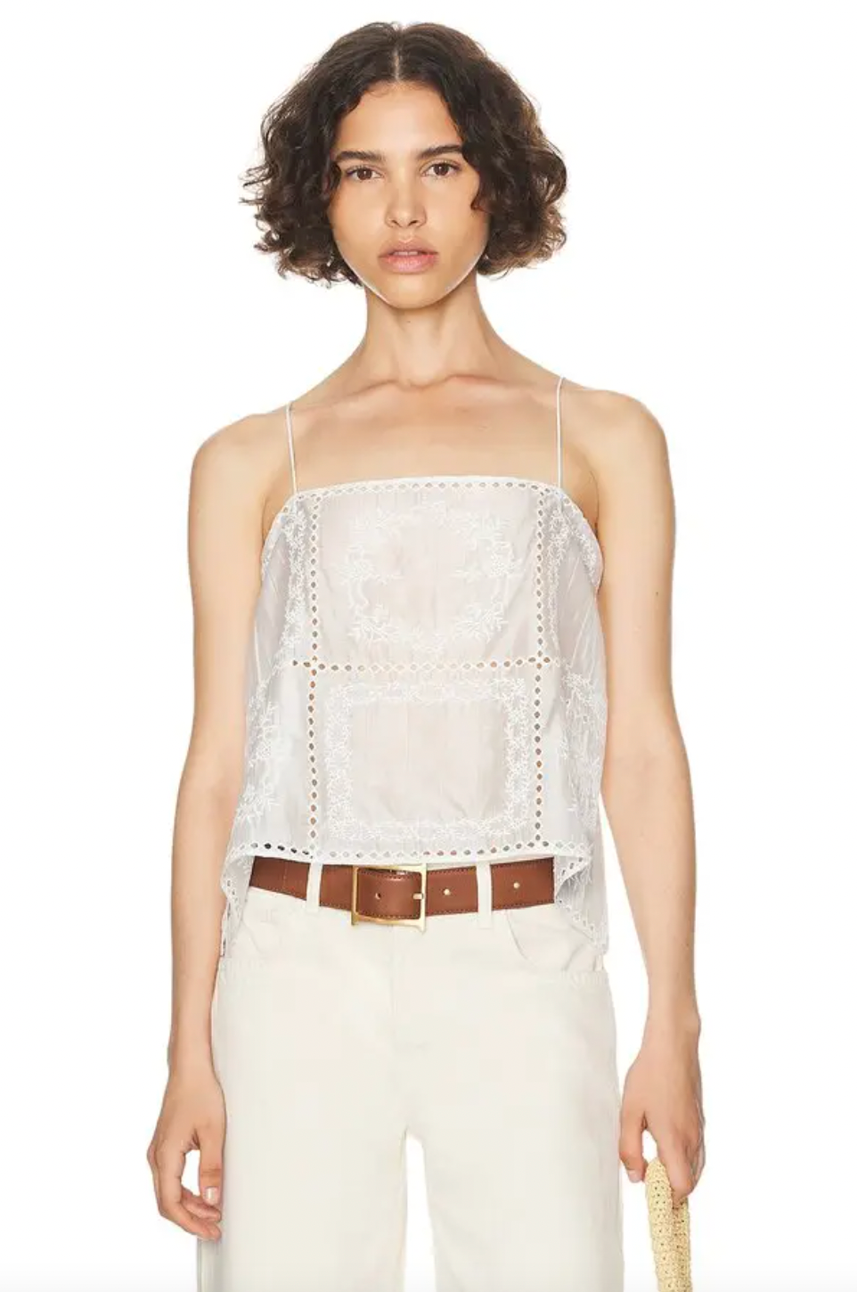 Introducing the Handkerchief Camisole by Helsa, crafted from luxurious linen and adorned with delicate eyelets and embroidered florals. The shoulder strap tie closures and side slits add a touch of sophistication. Perfect for warm weather, this garment is purposefully sheer, adding an alluring touch. Don't be afraid to let your undergarments peek through. Elevate your wardrobe with this elegant piece.