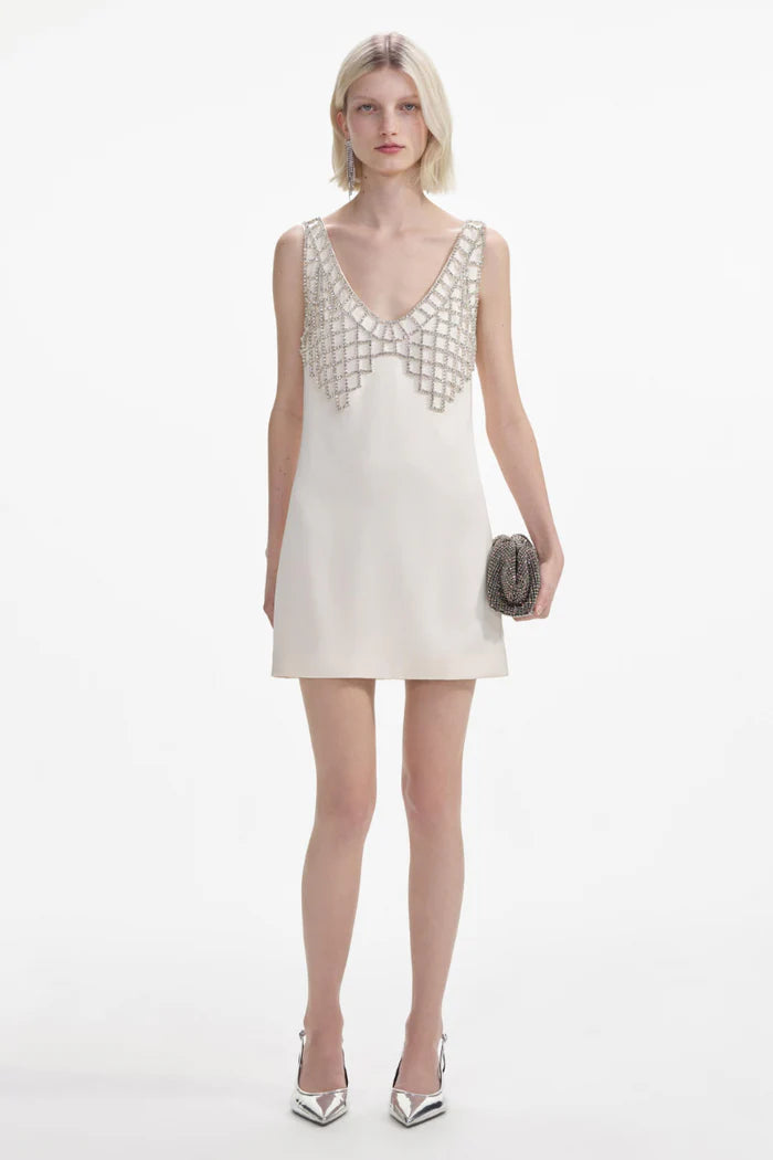 Indulge in after dark adventures with this cream satin mini dress by Self-portrait. The fitted style creates a sultry silhouette, while the removable diamanté bralette adds daring detail. Featuring a deep 'U' neckline and zip closure at the back, this dress is designed for a head-turning entrance.