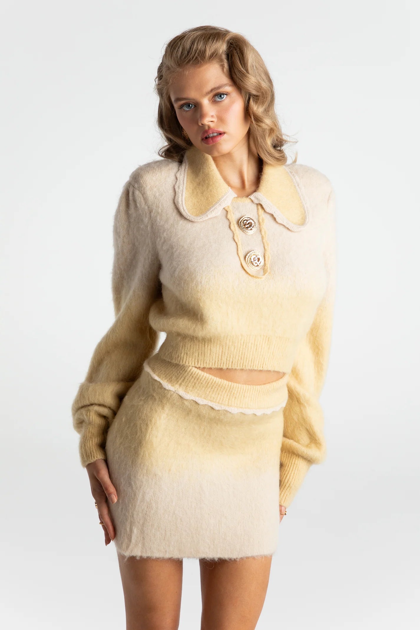 The Emily Set is the epitome of retro-glamour with its knit cardigan and bodycon skirt. The intricate stitching and gold custom buttons add a touch of elegance to this timeless two piece set. Made with luxurious alpaca wool yarn, this set is sure to keep you warm while making a statement. Complete with shoulder pads for added shape and style.