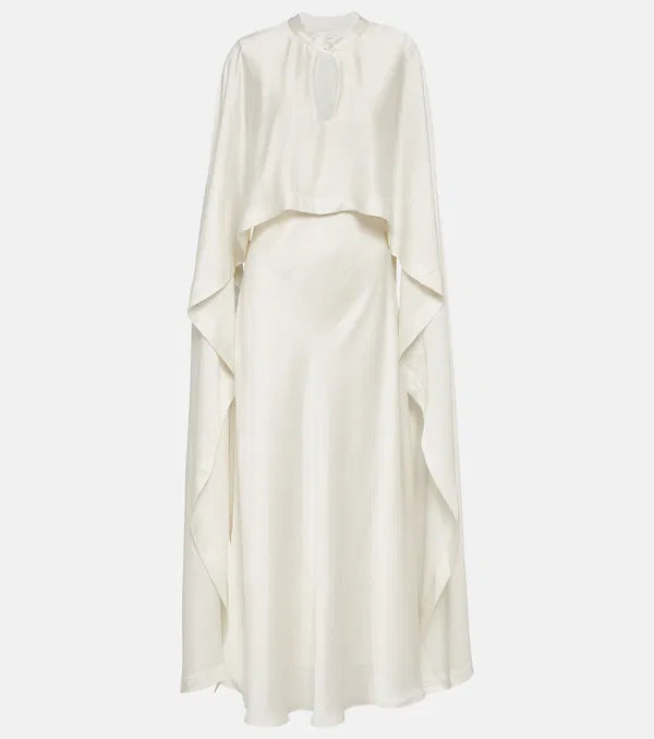 Sparkle and shine in the Amory Caped Gown by Simkhai. This bridal gown features intricate lace work, architectural silhouette, and luxurious materials for effortless chic and sophistication on your special day. Designed to flatter and accentuate the female form, it's the perfect choice for any bride looking for quality and craftsmanship.