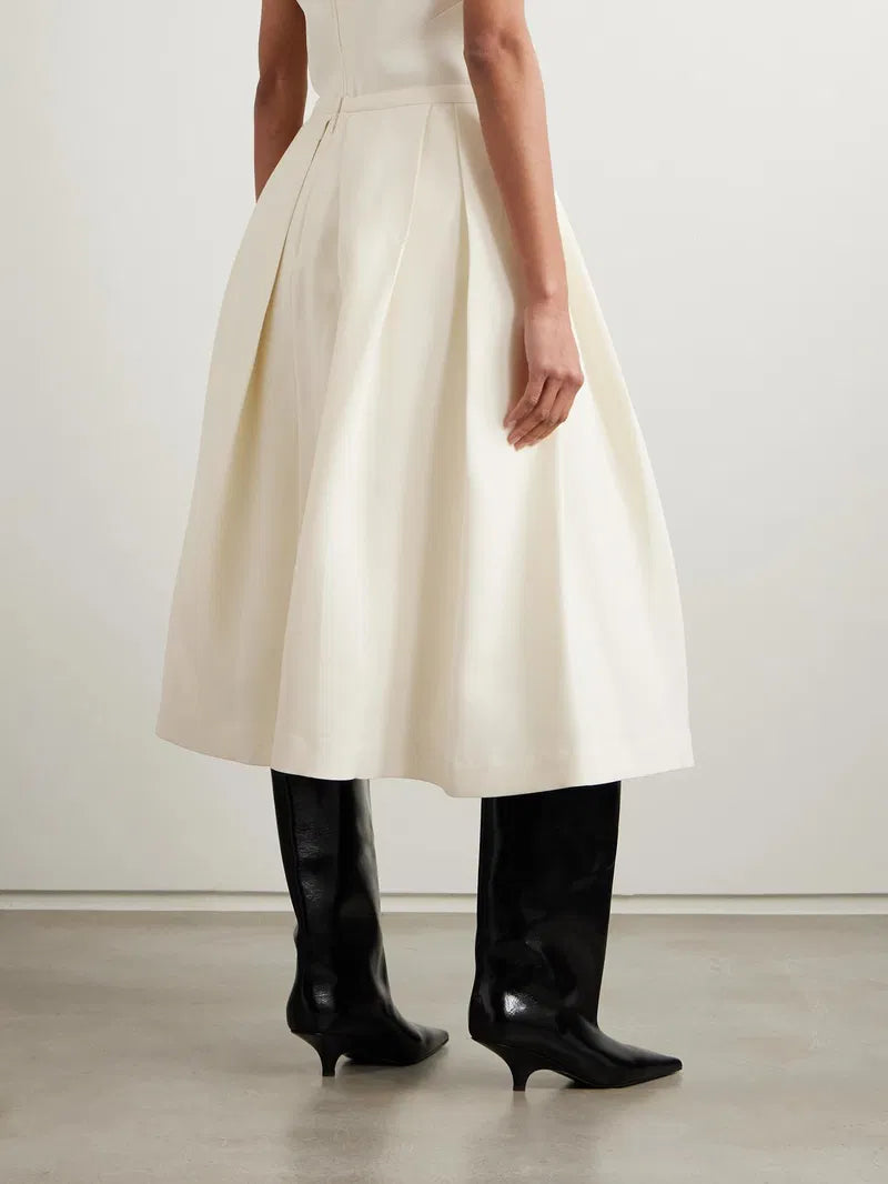 This versatile midi skirt combines timeless elegance with everyday wearability. Crafted from a luxurious wool and silk blend, it features deep pleats that create beautiful movement and dimension with every step. The refined design pairs effortlessly with knee boots, mules, or your favorite footwear, making it a wardrobe essential that transitions seamlessly from season to season. Invest in a piece that works as hard as you do.