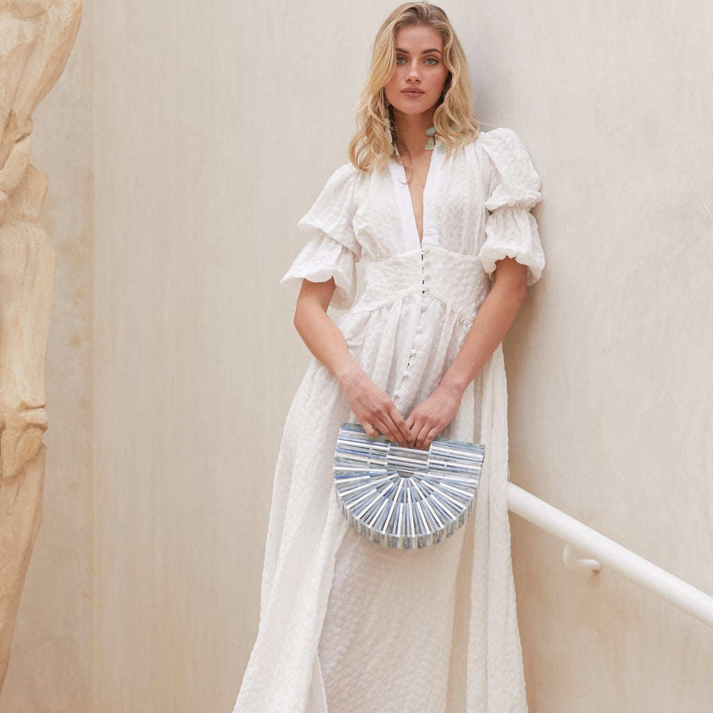 Indulge in luxurious elegance with the Willow Maxi Dress. This long frilled dress for women features a sexy V-neck and puffy half-sleeves, all in a crisp white color. Made from high-quality materials, it exudes sophistication and effortlessly exudes summer fashion.