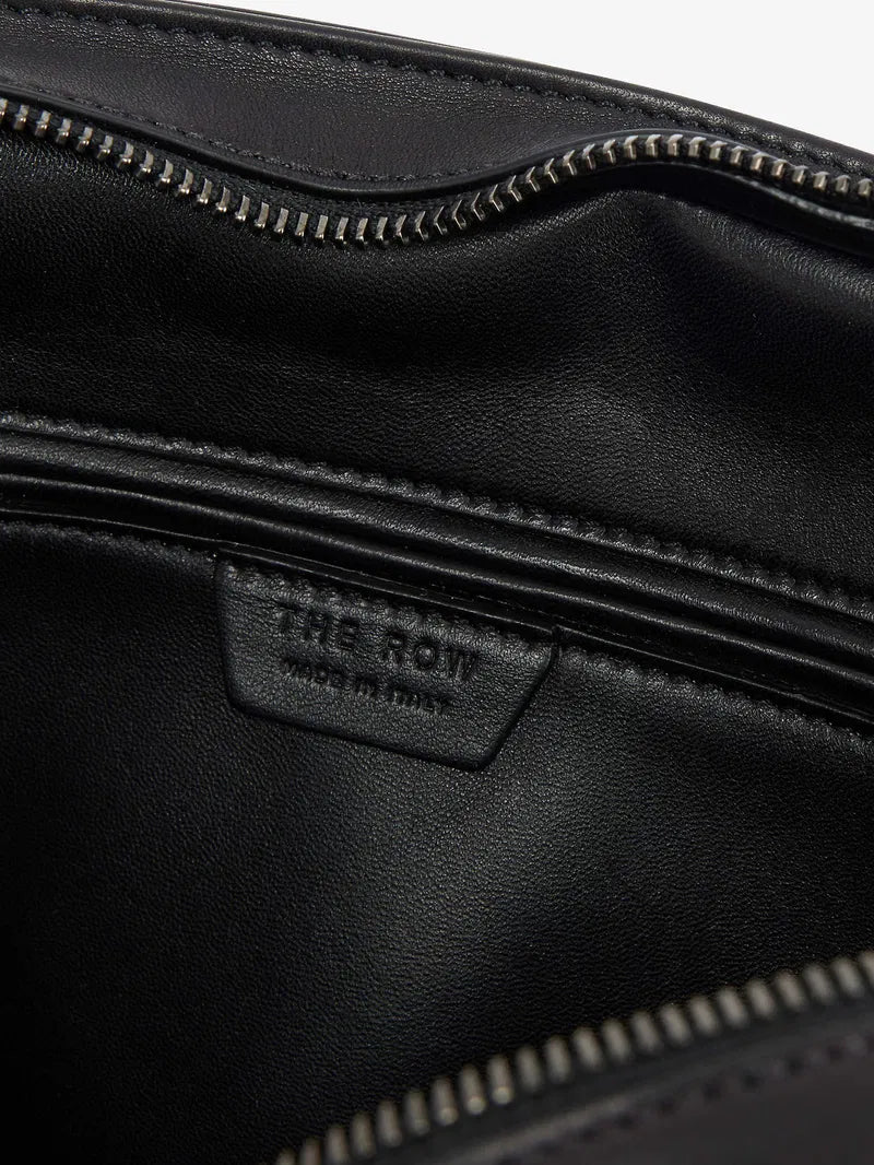 The Agnes tote by The Row combines understated luxury with everyday practicality. Crafted from polished saddle leather, this sophisticated bag features a softly slouched silhouette that moves with you, paired with sturdy tubular handles for effortless carrying. The secure zipper closure keeps your essentials protected while maintaining the bag's refined aesthetic. Perfect for those who appreciate timeless design and quality craftsmanship, the Agnes transitions seamlessly from work to weekend.