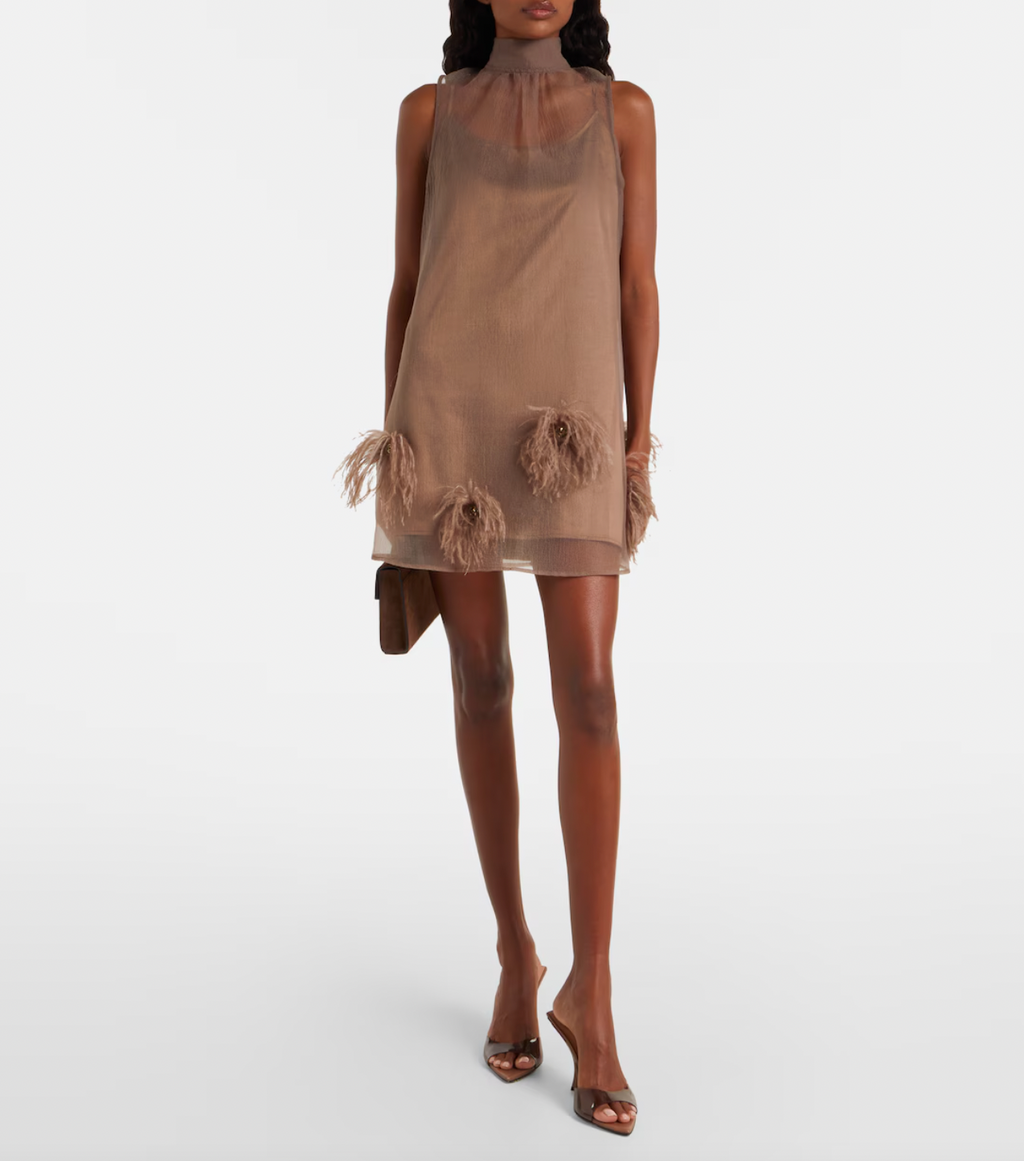 The Albee Feather-trimmed Minidress by Staud is your ticket to turning heads at any upscale occasion. This semi-sheer design combines sophistication with undeniable allure, featuring a flattering high neckline that frames the face beautifully. Luxurious feather trims add an unexpected glamorous edge, elevating the piece from elegant to extraordinary. 