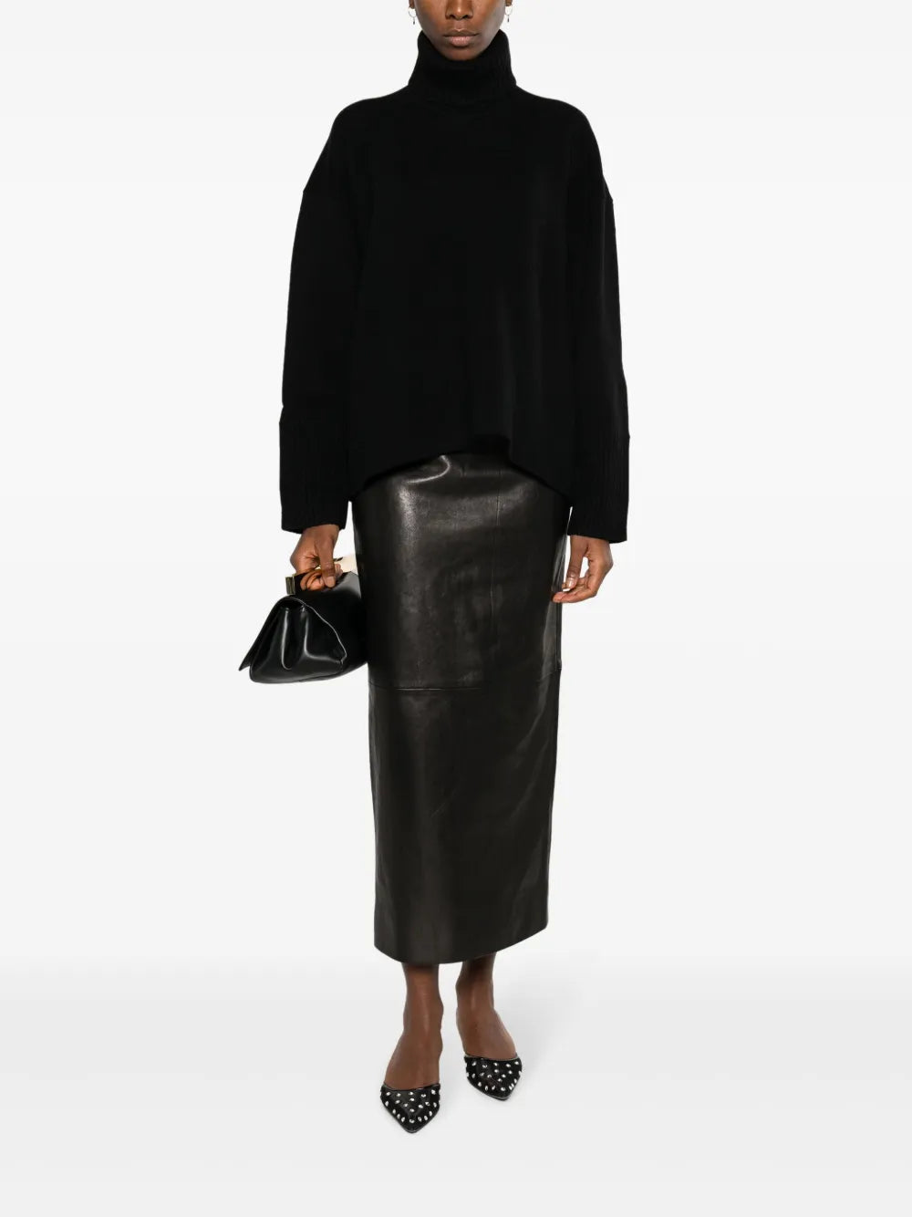 Discover timeless sophistication with KHAITE's Loxley leather midi skirt. Crafted from luxurious black lambskin with a smooth grain finish, this elevated pencil silhouette combines tailored precision with modern edge. The high-waisted cut flatters your frame while the dramatic rear slit adds movement and allure. A concealed zip fastening ensures a seamless look, making this American-made piece an essential investment for your wardrobe. Perfect for transitioning from boardroom to evening elegance.