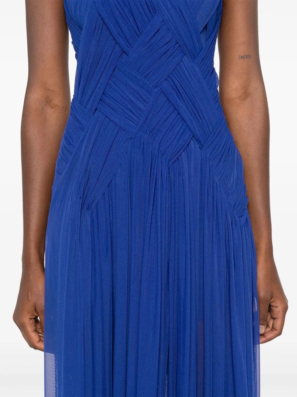 Embrace elegance with the Emotional braided maxi dress by Atu Body Couture. This stunning royal blue creation features intricate braid detailing and gathered accents that flow beautifully across a fully pleated silhouette. The mesh design adds an alluring touch, while the draped crew neck and sleeveless cut offer modern sophistication. The dramatic high-low hem transitions to a floor-length finish, creating movement with every step. 
