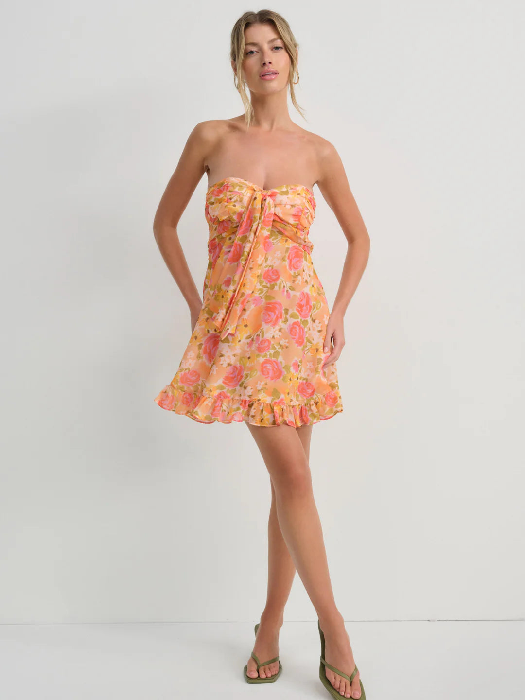 Embrace spring romance in the Teagan Mini Dress by For Love and Lemons, a stunning yellow chiffon creation designed to turn heads. This strapless beauty features a delicately gathered bust and charming tie detail that adds movement and personality to every step. Cut to a flirtatious mid-thigh length, it's the perfect balance of elegance and playfulness. Whether you're attending a garden party or enjoying a casual brunch, this floral-inspired piece delivers effortless sophistication with undeniable charm. 