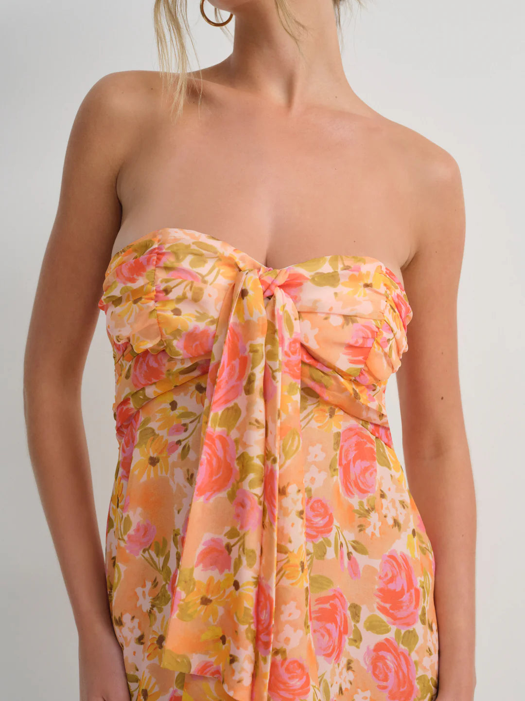 Embrace spring romance in the Teagan Mini Dress by For Love and Lemons, a stunning yellow chiffon creation designed to turn heads. This strapless beauty features a delicately gathered bust and charming tie detail that adds movement and personality to every step. Cut to a flirtatious mid-thigh length, it's the perfect balance of elegance and playfulness. Whether you're attending a garden party or enjoying a casual brunch, this floral-inspired piece delivers effortless sophistication with undeniable charm. 