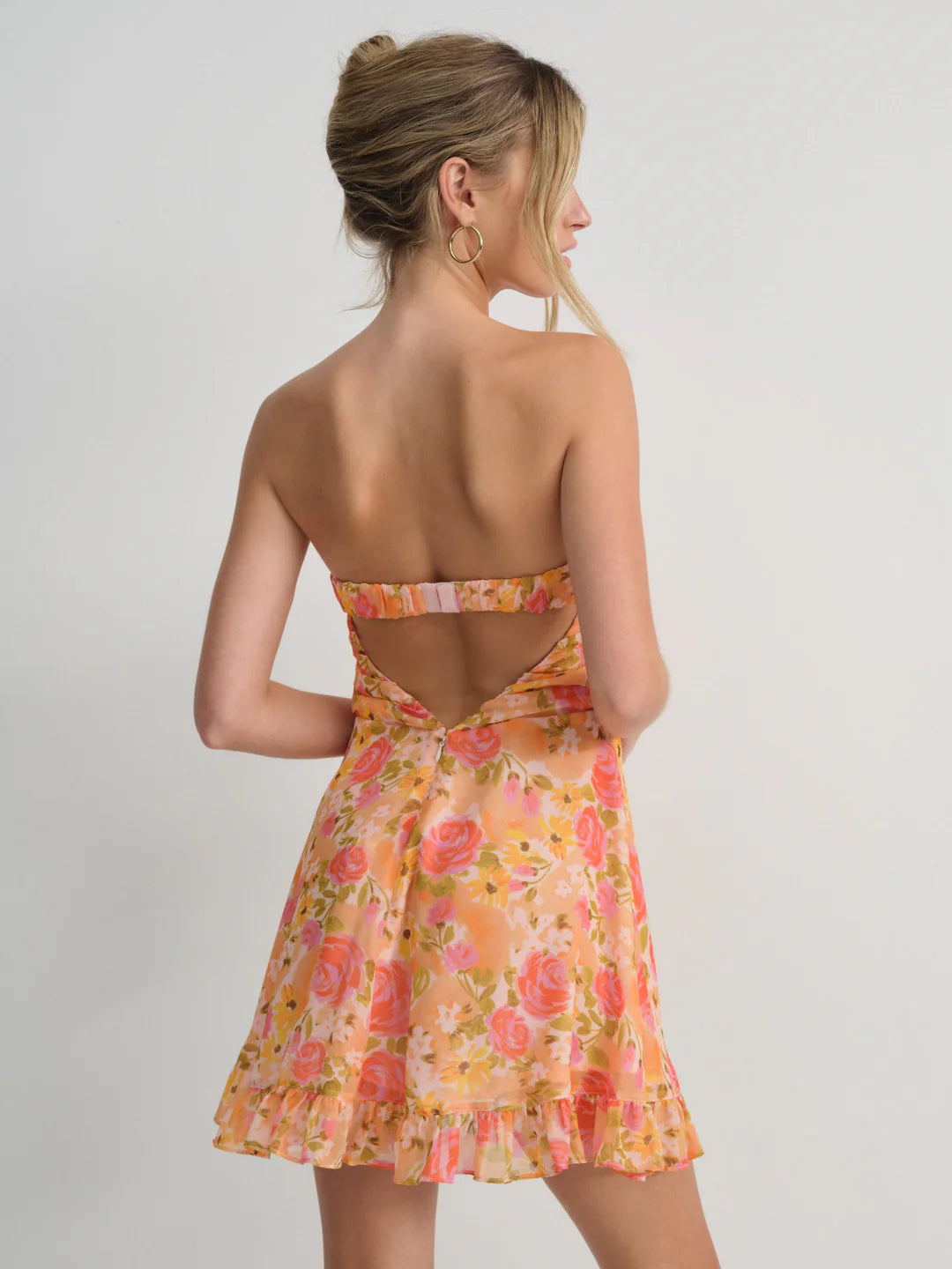 Embrace spring romance in the Teagan Mini Dress by For Love and Lemons, a stunning yellow chiffon creation designed to turn heads. This strapless beauty features a delicately gathered bust and charming tie detail that adds movement and personality to every step. Cut to a flirtatious mid-thigh length, it's the perfect balance of elegance and playfulness. Whether you're attending a garden party or enjoying a casual brunch, this floral-inspired piece delivers effortless sophistication with undeniable charm. 