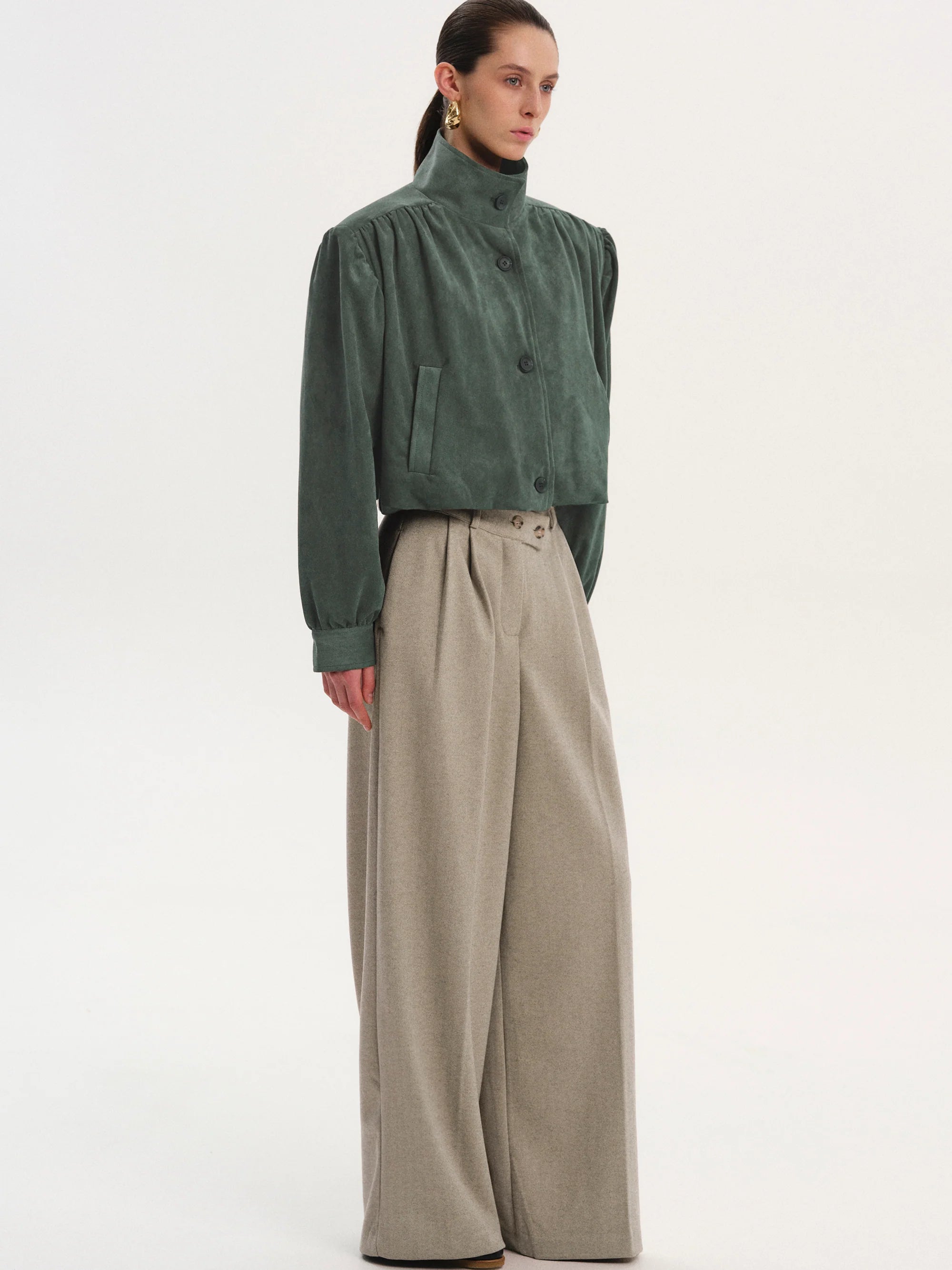 This Ruched Suede Jacket in Grey blends timeless style with contemporary flair. Featuring a boxy silhouette and padded shoulders, it exudes confidence, while the stand collar and gathered pleats add refined detail. The softly structured waistband creates a relaxed blouson effect, offering a polished look that’s both comfortable and stylish. Fully lined for all-day ease, this jacket effortlessly enhances any outfit with understated sophistication.