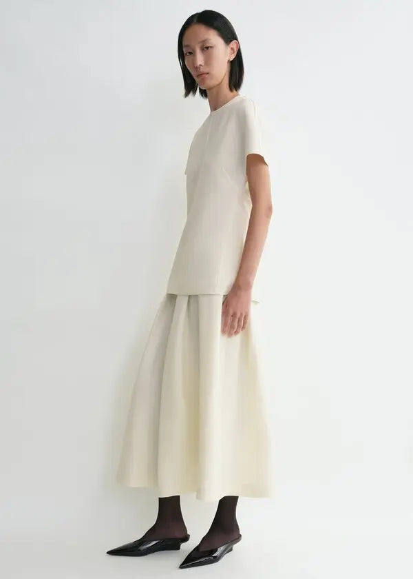 Discover understated luxury with this cap-sleeve top by Toteme, where contemporary design meets timeless sophistication. The elongated cut creates a flattering silhouette while twisted seams introduce subtle architectural detail. Constructed from premium double-faced cady blended with wool and silk, it delivers exceptional comfort without compromising on durability. A hidden back zipper provides a clean, refined finish—perfect for seamless layering or standalone elegance. 