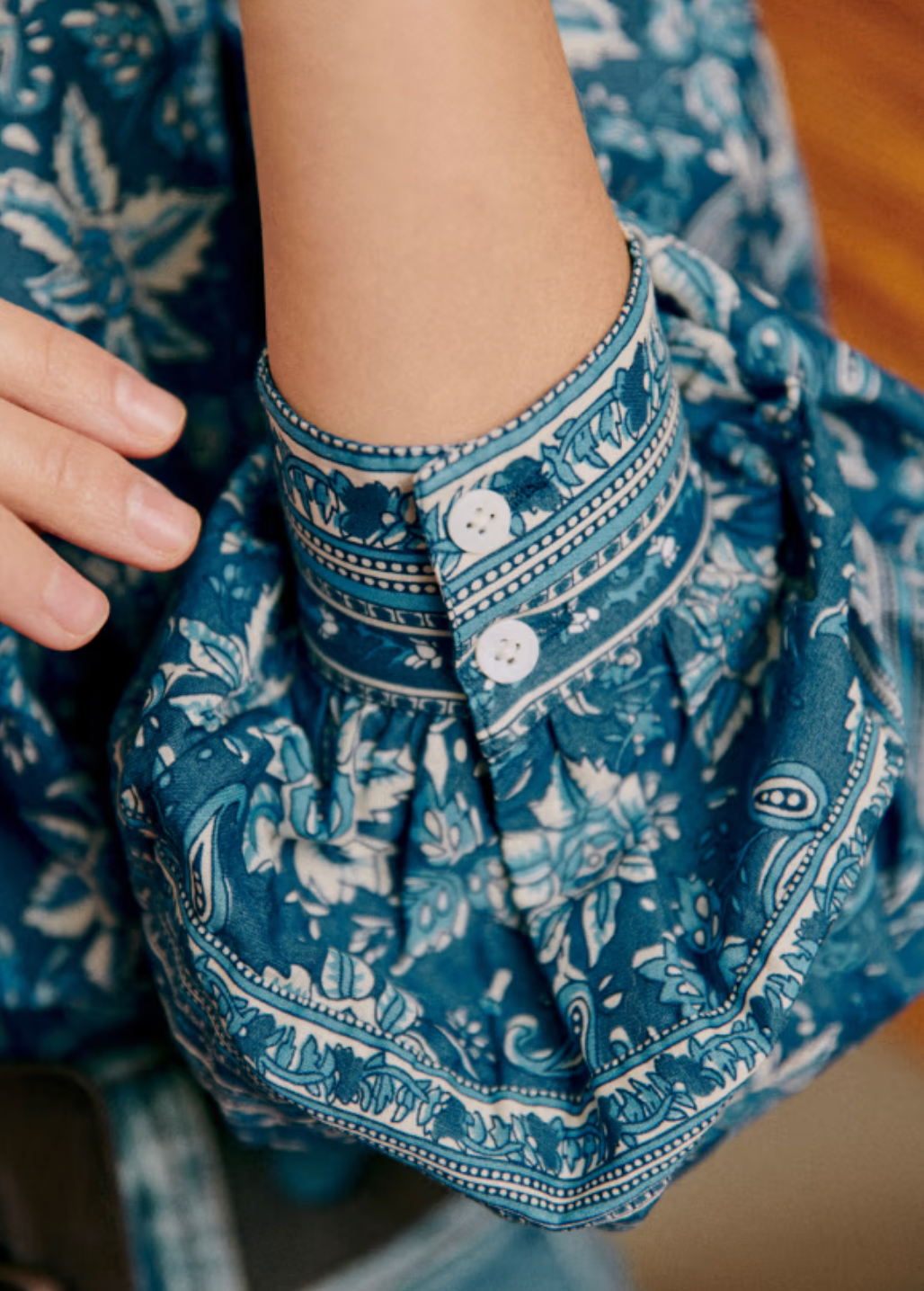 The Mariana Shirt by Sezane combines classic sophistication with modern style. Featuring an officer collar and button-down front, this long sleeve shirt offers a polished look perfect for any occasion. Its wide sleeves are elegantly gathered at the shoulders and cuffs, creating a graceful silhouette that cinches at the wrist for a tailored finish. Elevate your wardrobe with this statement piece that balances comfort and chic design effortlessly.