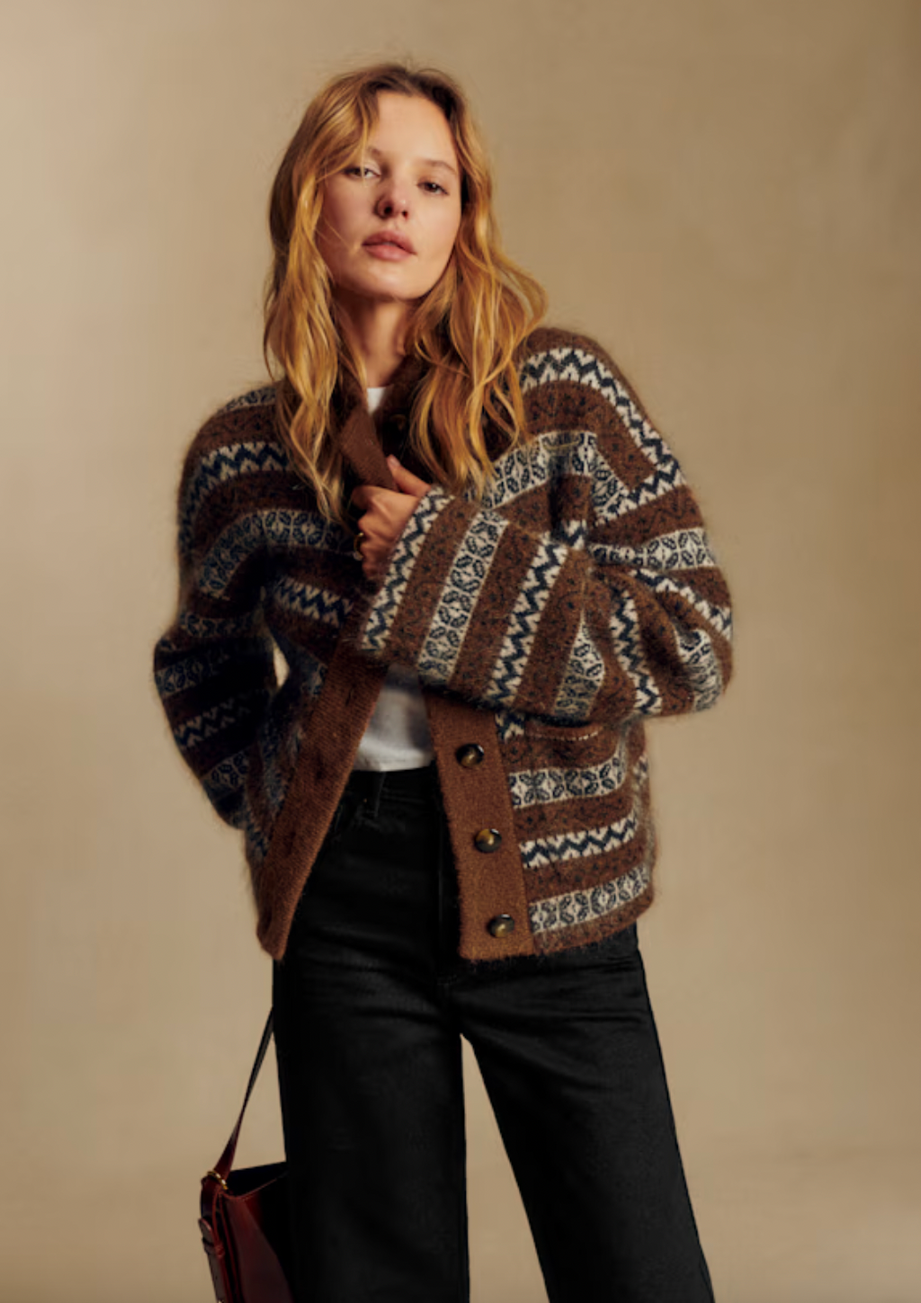 The Thais Jacket combines luxurious comfort with effortless style. Crafted from a sumptuous blend of wool and kid mohair, this piece features intricate jacquard knitting that adds visual depth and sophistication. The slightly oversized silhouette drapes beautifully while maintaining structure, perfect for layering or wearing solo. A plush teddy collar frames the neckline with cozy elegance, while functional front pockets add practical appeal. 