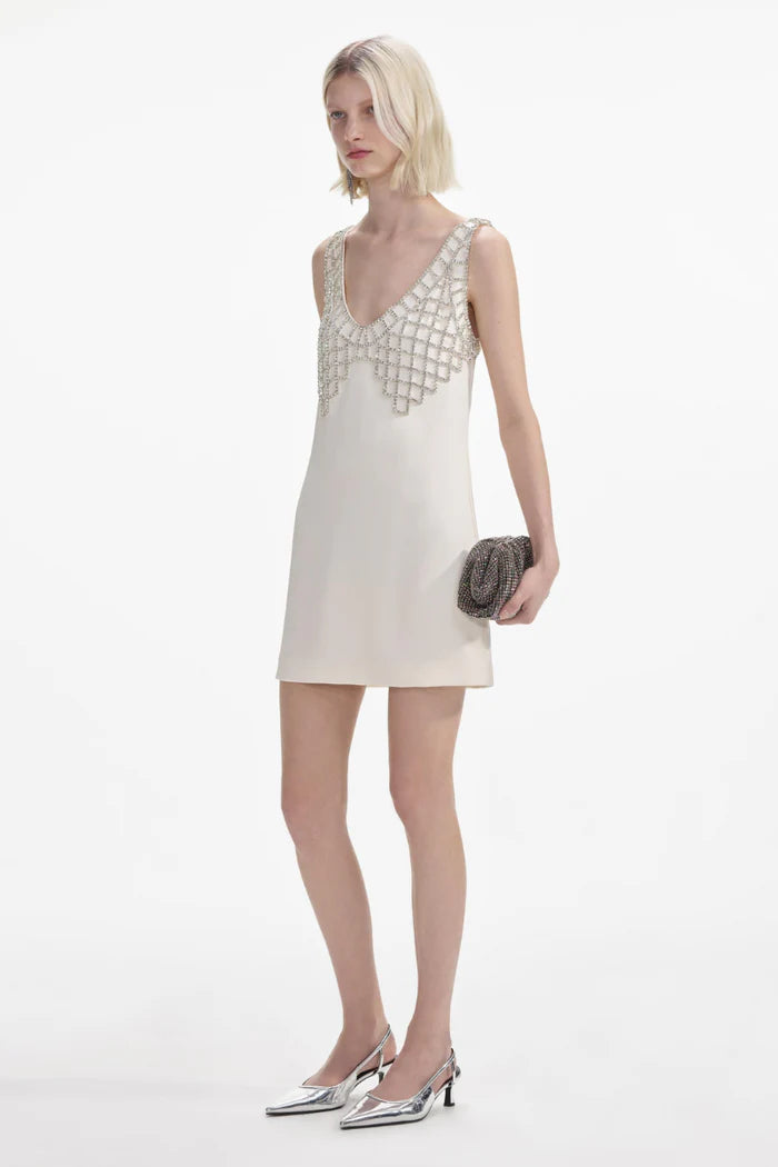 Indulge in after dark adventures with this cream satin mini dress by Self-portrait. The fitted style creates a sultry silhouette, while the removable diamanté bralette adds daring detail. Featuring a deep 'U' neckline and zip closure at the back, this dress is designed for a head-turning entrance.