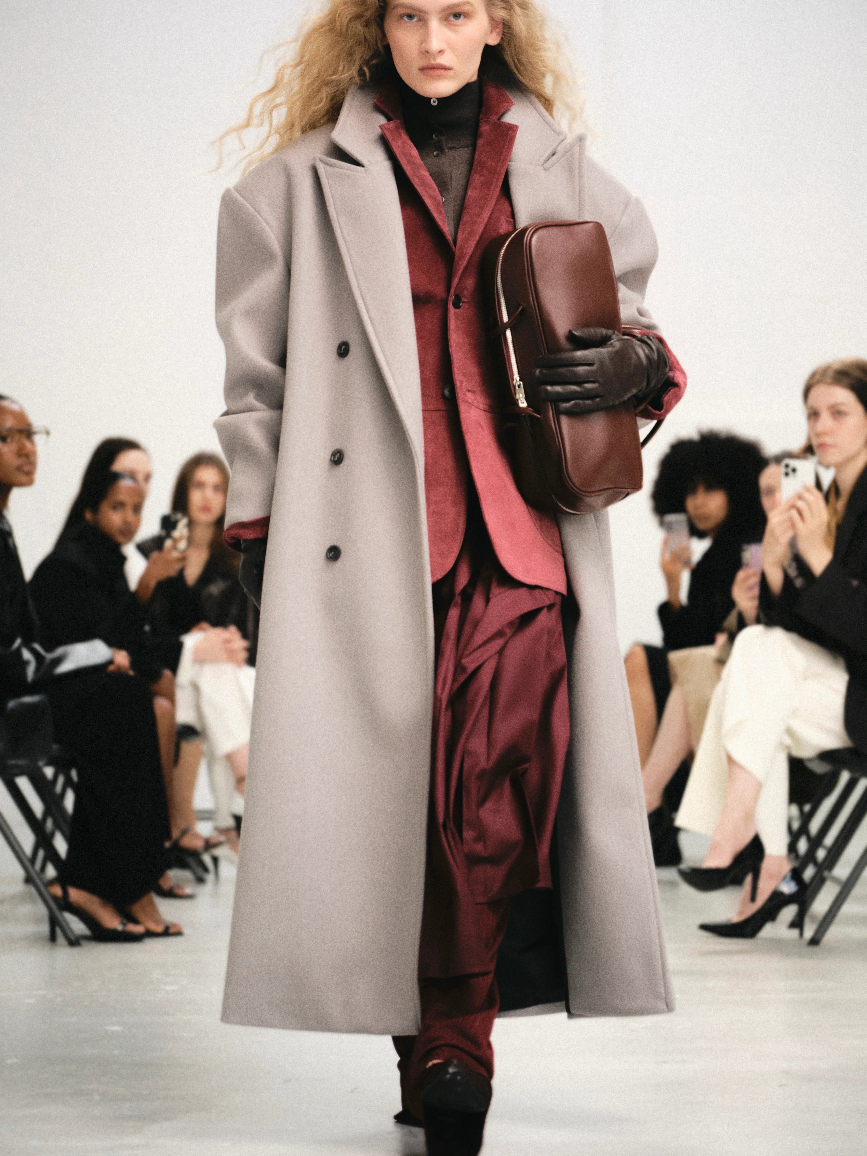 Embrace effortless sophistication with the Wallis Oversized Grandpa Coat, a contemporary take on timeless tailoring. Crafted from mid-weight bonded wool-blend fabric, this unisex piece features a dramatically oversized silhouette that commands attention. The striking long peak lapels and double-breasted closure create architectural interest, while structured shoulder pads deliver modern edge. 