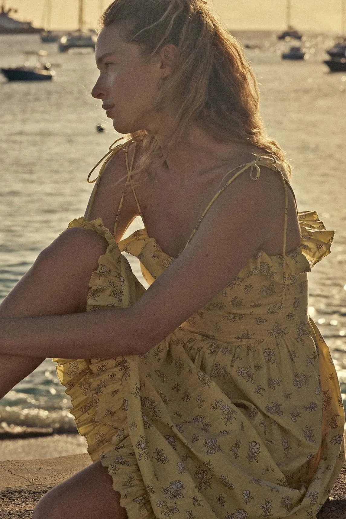 Indulge in the elegance of the Wendelin Midi Dress by Dôen. This beautiful cotton dress features a charming yellow, brown, and cream floral pattern, along with a flattering v waist and adjustable straps for a perfect fit. The delicate ruffle adds a playful touch to this sophisticated and exclusive sundress.