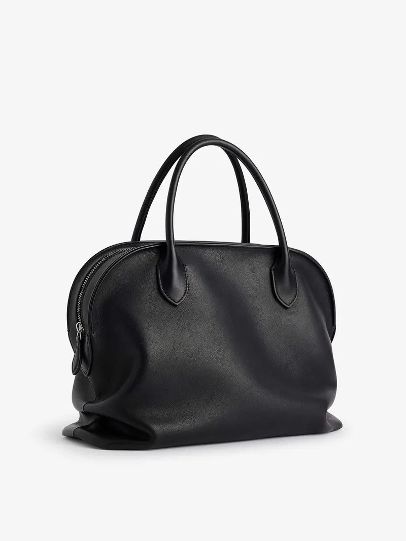 The Agnes tote by The Row combines understated luxury with everyday practicality. Crafted from polished saddle leather, this sophisticated bag features a softly slouched silhouette that moves with you, paired with sturdy tubular handles for effortless carrying. The secure zipper closure keeps your essentials protected while maintaining the bag's refined aesthetic. Perfect for those who appreciate timeless design and quality craftsmanship, the Agnes transitions seamlessly from work to weekend.