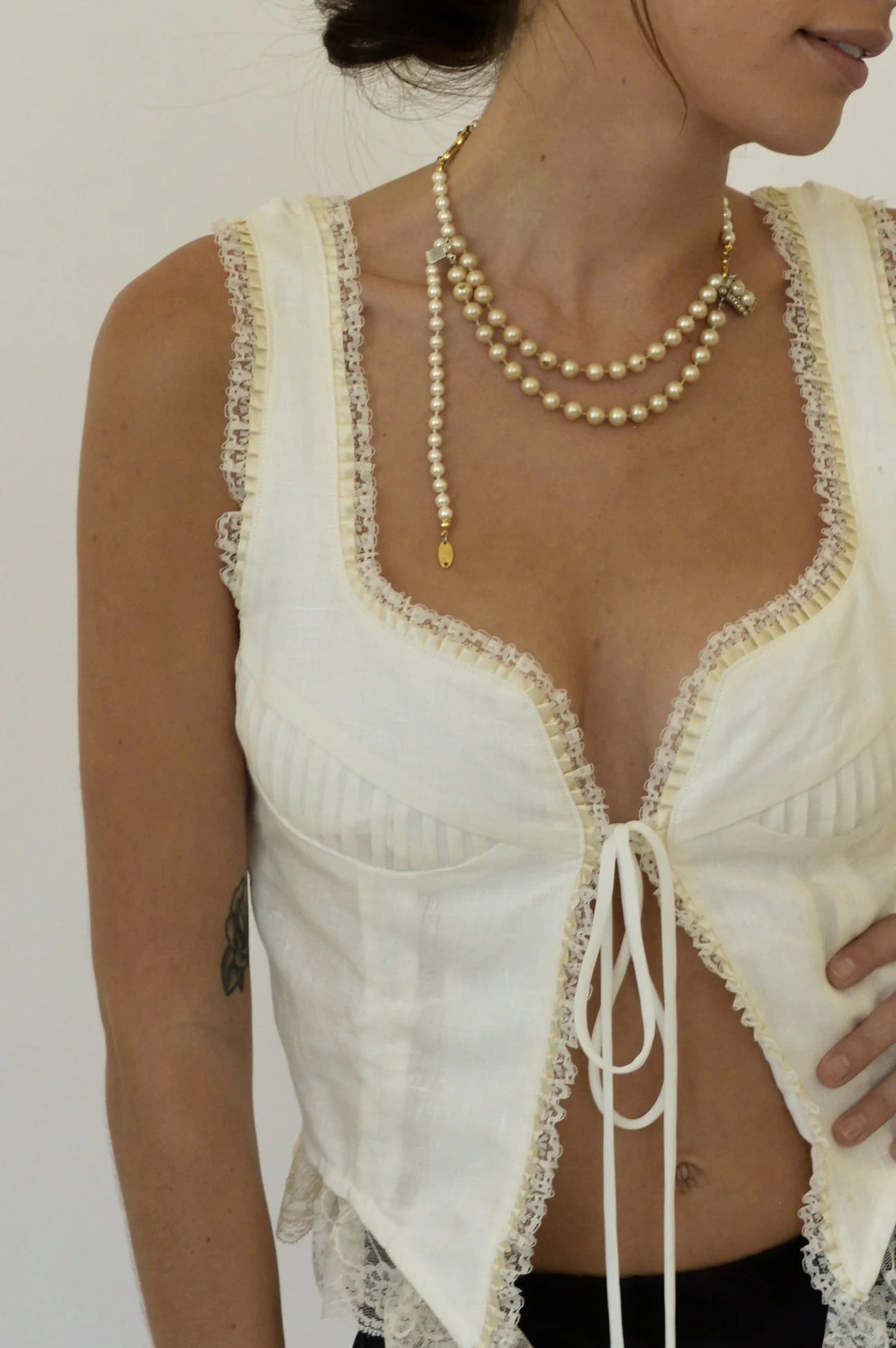 Indulge in the sophistication of the Top Renee. Crafted with 100% linen, its tie front and adjustable back ties provide the perfect fit. The delicate lace and pintuck detailing add a touch of elegance to this timeless piece. Elevate your wardrobe with this luxurious top.