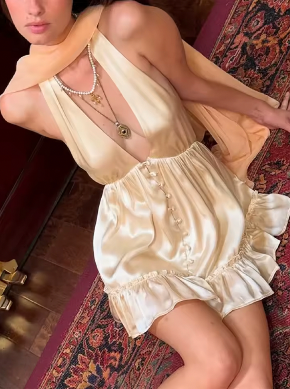 Experience elegance with the Caroline Silk Dress by Fait par Foutch. Made from medium-weight 100% silk charmeuse, this dress offers a smooth, luxurious feel and graceful drape. Fully lined with pure silk, it ensures all-day comfort. Functional silk-covered buttons adorn the front, while the adjustable halter straps tie into a bow for a perfect fit. The low V-neck and back, combined with hidden elastic at the waist, create a flattering silhouette that moves with you. 