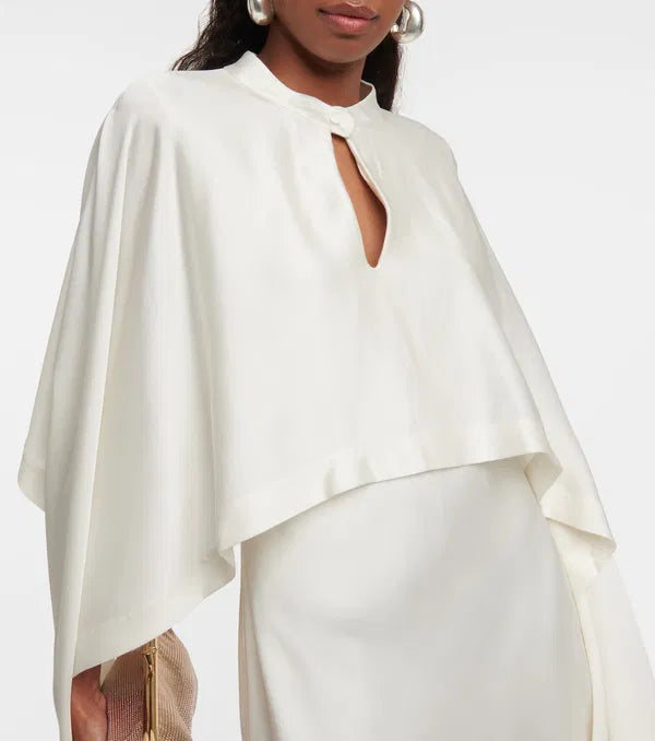 Sparkle and shine in the Amory Caped Gown by Simkhai. This bridal gown features intricate lace work, architectural silhouette, and luxurious materials for effortless chic and sophistication on your special day. Designed to flatter and accentuate the female form, it's the perfect choice for any bride looking for quality and craftsmanship.