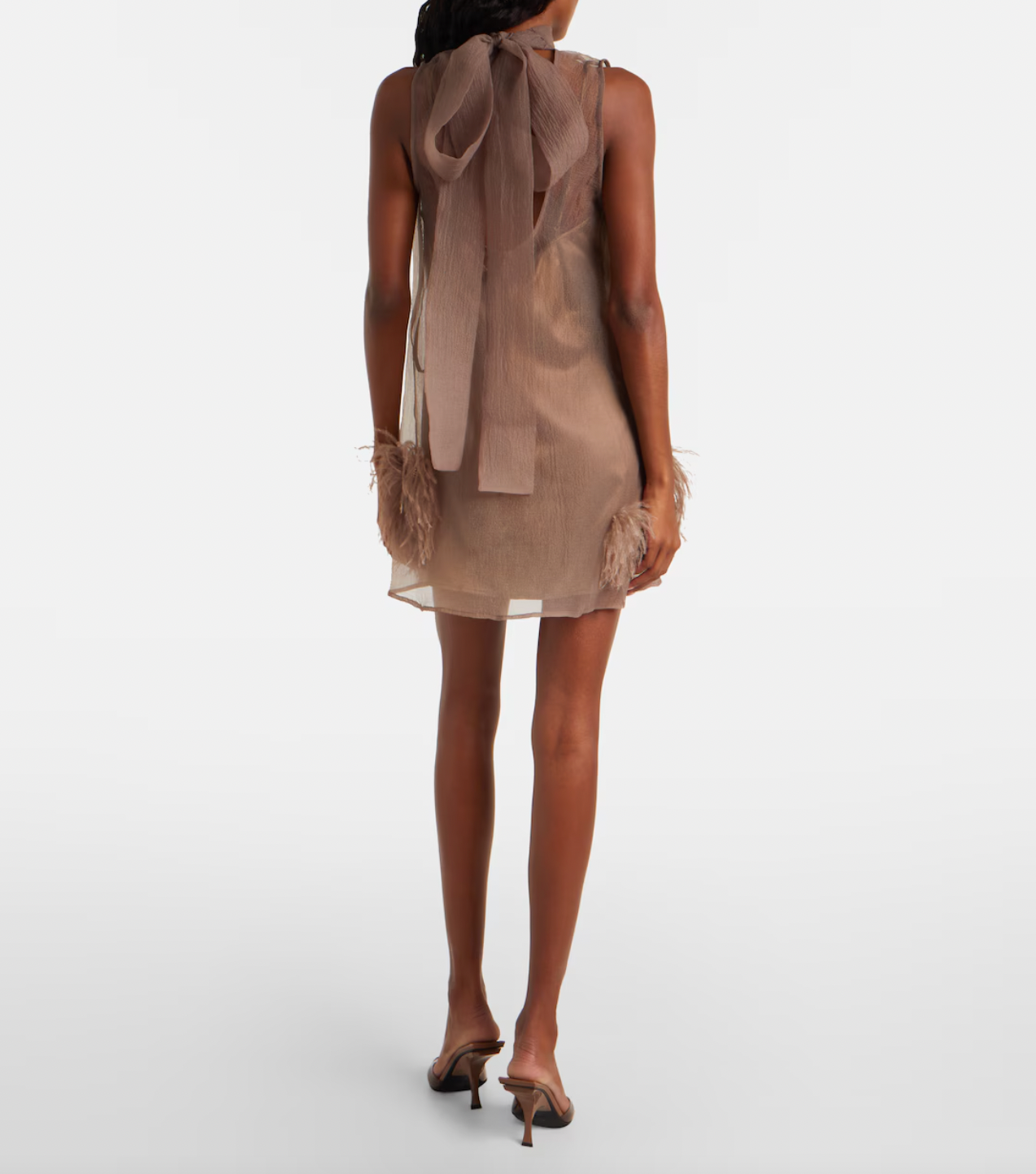 The Albee Feather-trimmed Minidress by Staud is your ticket to turning heads at any upscale occasion. This semi-sheer design combines sophistication with undeniable allure, featuring a flattering high neckline that frames the face beautifully. Luxurious feather trims add an unexpected glamorous edge, elevating the piece from elegant to extraordinary. 