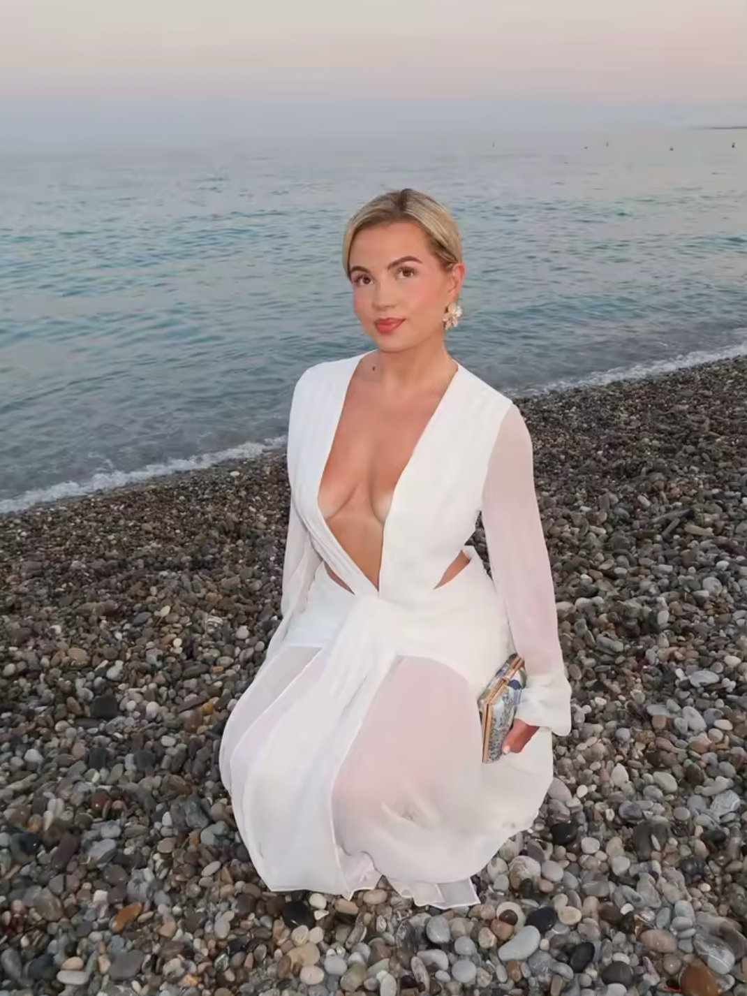 The Andrina Maxi Dress is a stunning statement piece that combines romance with modern elegance. Crafted from delicate chiffon, this maxi features long, sheer blouson sleeves and a daring deep plunge neckline that exudes confidence. The open lace-up back with adjustable ties allows you to customize your fit while showcasing an alluring silhouette. 