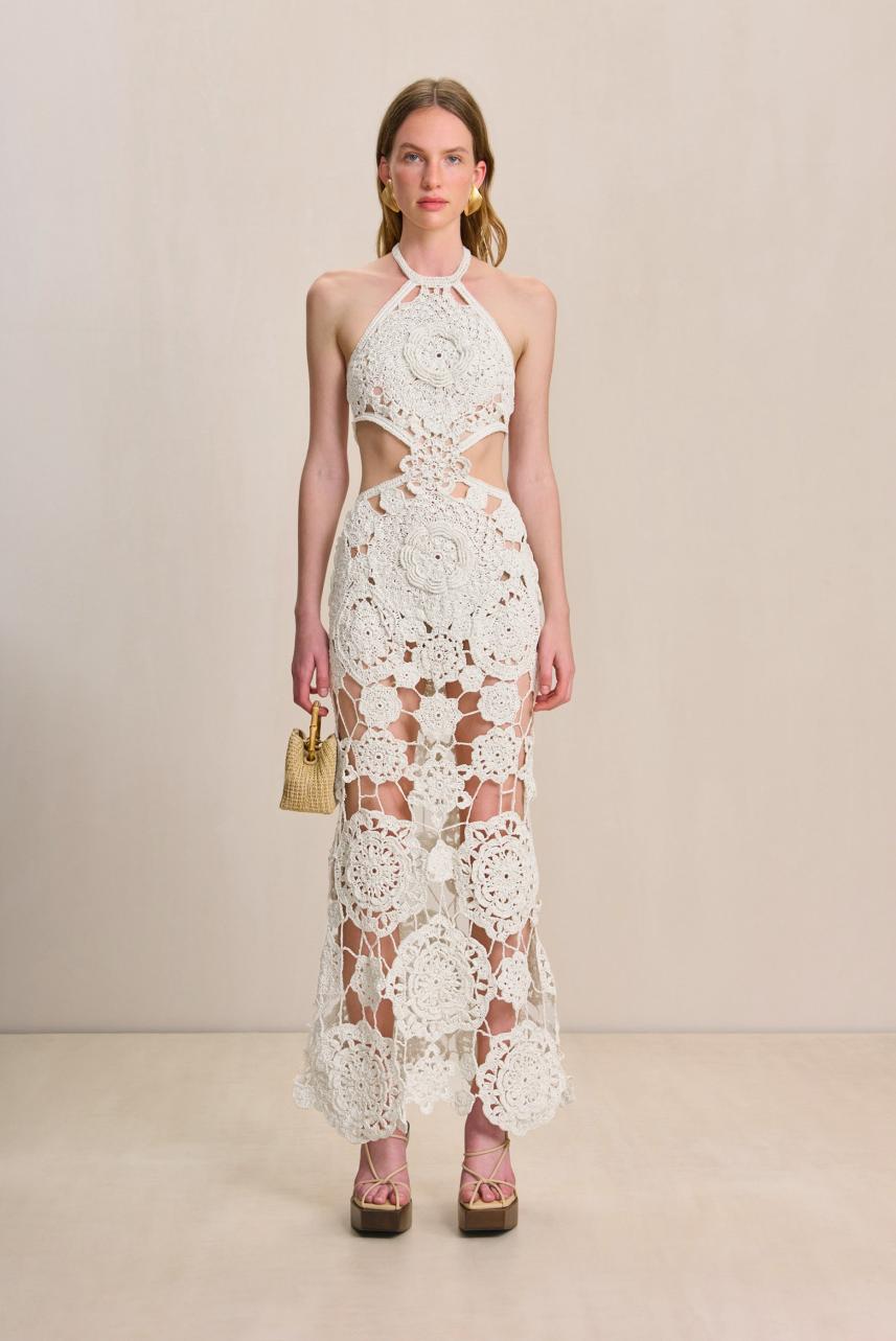 This Accalia Crochet Gown by Cult Gaia is a true work of art, featuring hand-crocheted geometric and floral patterns. With cutouts at the waist, an open-knit design, and a halter neckline, this gown is both elegant and alluring. The open back with two straps and elastic waistband ensure a perfect fit, while the adjustable neck tie adds a touch of versatility. Be prepared to turn heads in this ankle-length masterpiece.