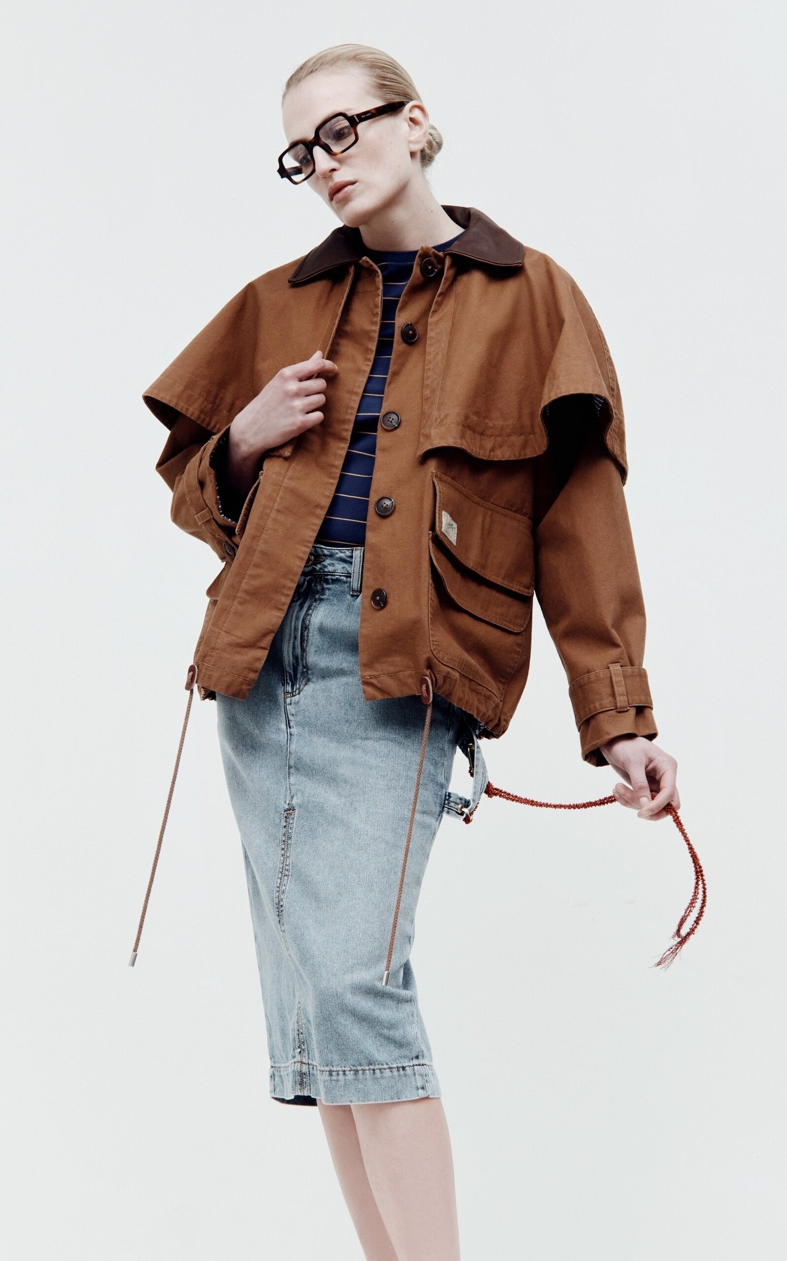 Embrace effortless sophistication with the Carolyn Cape-Detailed Cotton Workwear Jacket by SEA NY. This statement piece combines utilitarian charm with unexpected elegance, featuring a structured oversized silhouette crafted from crisp cotton canvas. The signature flouncy capelet adds a playful twist to classic workwear styling, making it perfect for elevating everyday looks or creating bold, fashion-forward outfits. 