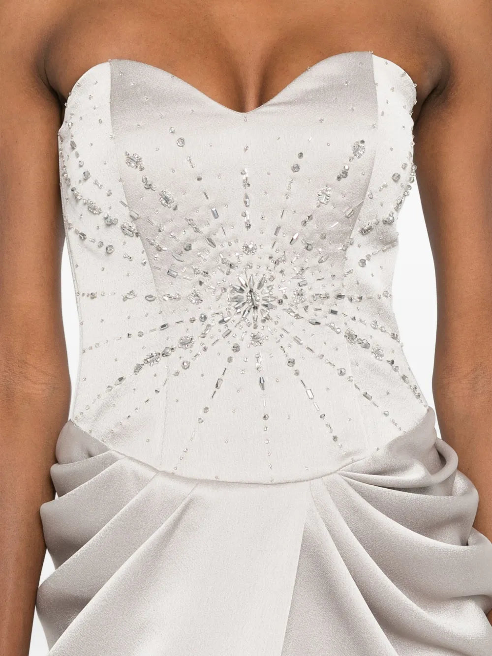 The Fabiana dress by M.Marquise is an imported evening gown that commands attention. This strapless masterpiece features elegant draped detailing and cascades to a dramatic floor length, creating an effortlessly sophisticated silhouette. Shimmering silver-tone crystal embellishments catch the light with every movement, adding glamorous sparkle to your most memorable moments. Perfect for galas, weddings, or upscale celebrations where timeless elegance matters.