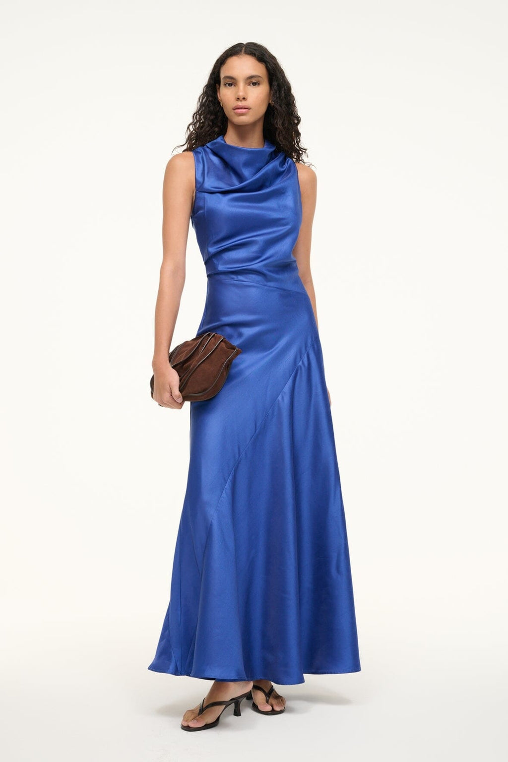 Embrace timeless elegance with the Frida Silk Dress in Deep Sea by Staud. This stunning sleeveless gown features a graceful cowl neckline and a fitted waist that flows into a sweeping A-line skirt, creating a silhouette that flatters and captivates. Crafted from luxurious silk dupioni fabric, this dress offers a subtle texture and natural sheen that catches the light beautifully. 