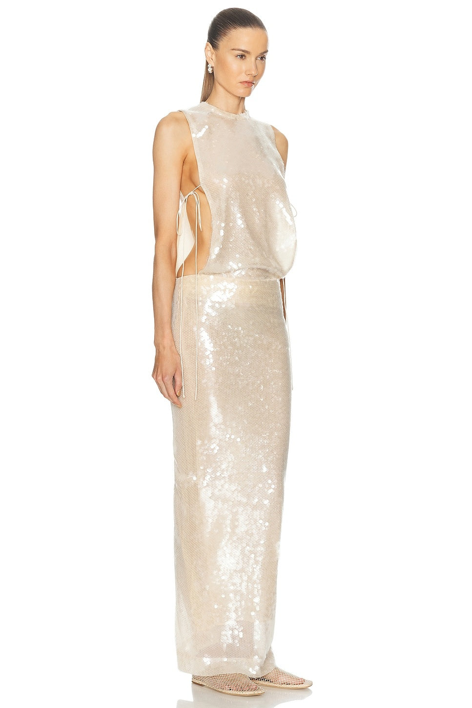 Elevate your evening presence with the Lucent Sequin Separation Gown by Christopher Esber, crafted in dazzling sequin-embellished fabric for a radiant glow. This fully lined gown features a sleek shoulder zipper closure for a smooth fit, elastic stretch at the waist for comfort, and a stylish back slit that adds graceful movement. Open sides with delicate tie-up accents create a modern silhouette, perfect for making a lasting impression. 