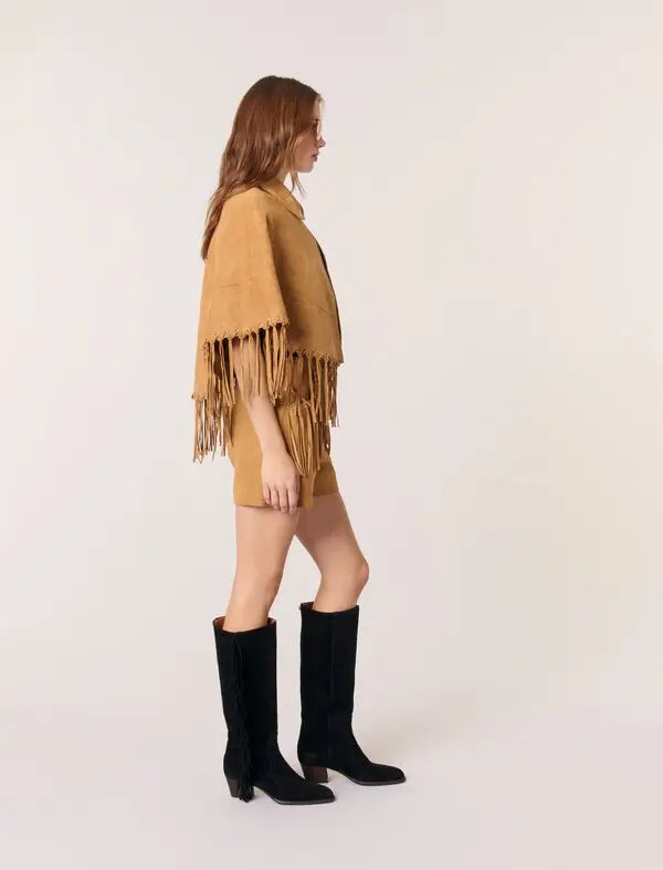 This Short Leather Fringed Cape by Maje combines the luxurious texture of suede with a striking cape design, featuring delicate fringed edges and polished silver eyelets for an edgy yet elegant look. Its classic shirt collar and secure hook-and-eye fastening ensure both style and comfort, making it a standout piece that elevates any outfit with effortless sophistication.