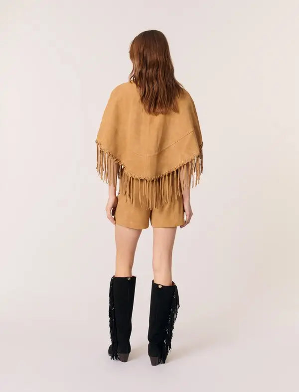 This Short Leather Fringed Cape by Maje combines the luxurious texture of suede with a striking cape design, featuring delicate fringed edges and polished silver eyelets for an edgy yet elegant look. Its classic shirt collar and secure hook-and-eye fastening ensure both style and comfort, making it a standout piece that elevates any outfit with effortless sophistication.