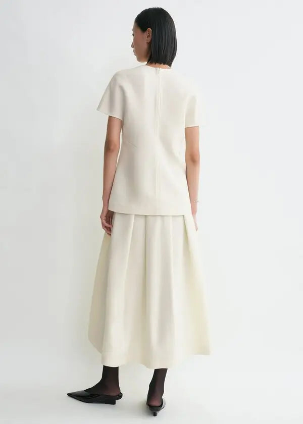 Discover understated luxury with this cap-sleeve top by Toteme, where contemporary design meets timeless sophistication. The elongated cut creates a flattering silhouette while twisted seams introduce subtle architectural detail. Constructed from premium double-faced cady blended with wool and silk, it delivers exceptional comfort without compromising on durability. A hidden back zipper provides a clean, refined finish—perfect for seamless layering or standalone elegance. 