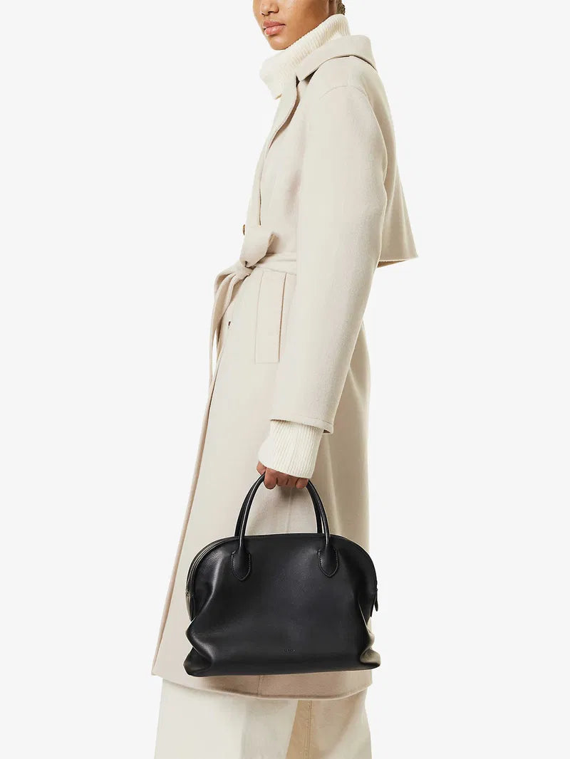 The Agnes tote by The Row combines understated luxury with everyday practicality. Crafted from polished saddle leather, this sophisticated bag features a softly slouched silhouette that moves with you, paired with sturdy tubular handles for effortless carrying. The secure zipper closure keeps your essentials protected while maintaining the bag's refined aesthetic. Perfect for those who appreciate timeless design and quality craftsmanship, the Agnes transitions seamlessly from work to weekend.