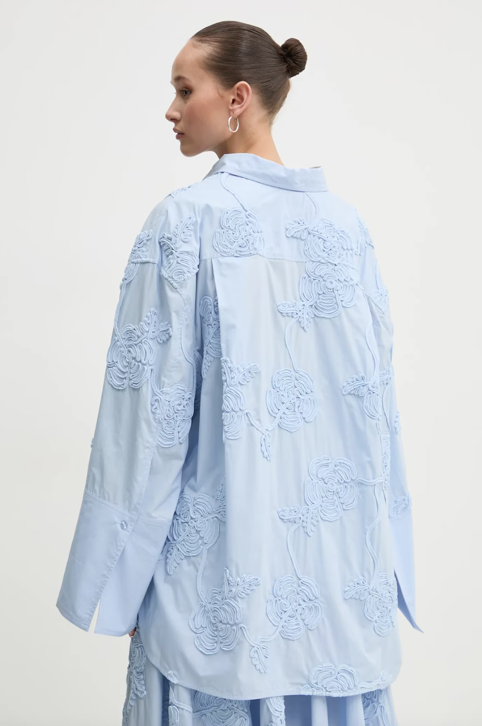 Elevate your style with this high-waisted maxi skirt crafted from sustainable organic cotton. Its flowing, flared design moves gracefully, enhanced by delicate tonal floral embroidery that adds elegant texture. With carefully tailored gathering at the waistband and a hidden side zipper, it offers a flattering fit and lasting comfort. Ideal for sophisticated events, this skirt combines refined elegance with eco-conscious craftsmanship to enhance your wardrobe effortlessly.