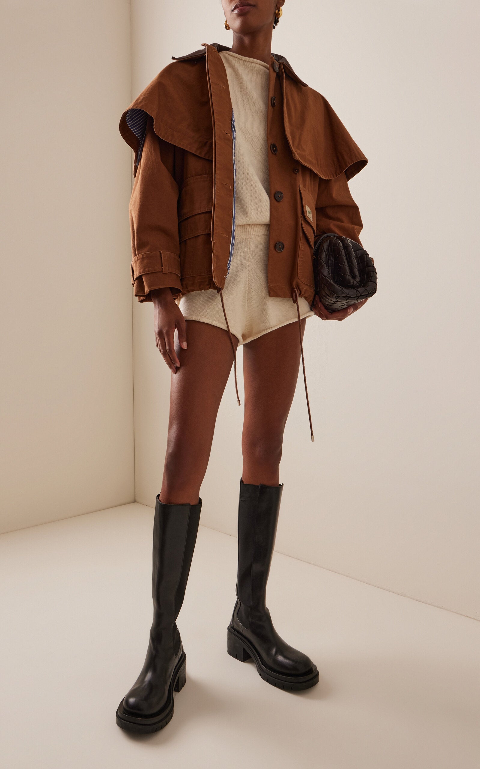 Embrace effortless sophistication with the Carolyn Cape-Detailed Cotton Workwear Jacket by SEA NY. This statement piece combines utilitarian charm with unexpected elegance, featuring a structured oversized silhouette crafted from crisp cotton canvas. The signature flouncy capelet adds a playful twist to classic workwear styling, making it perfect for elevating everyday looks or creating bold, fashion-forward outfits. 