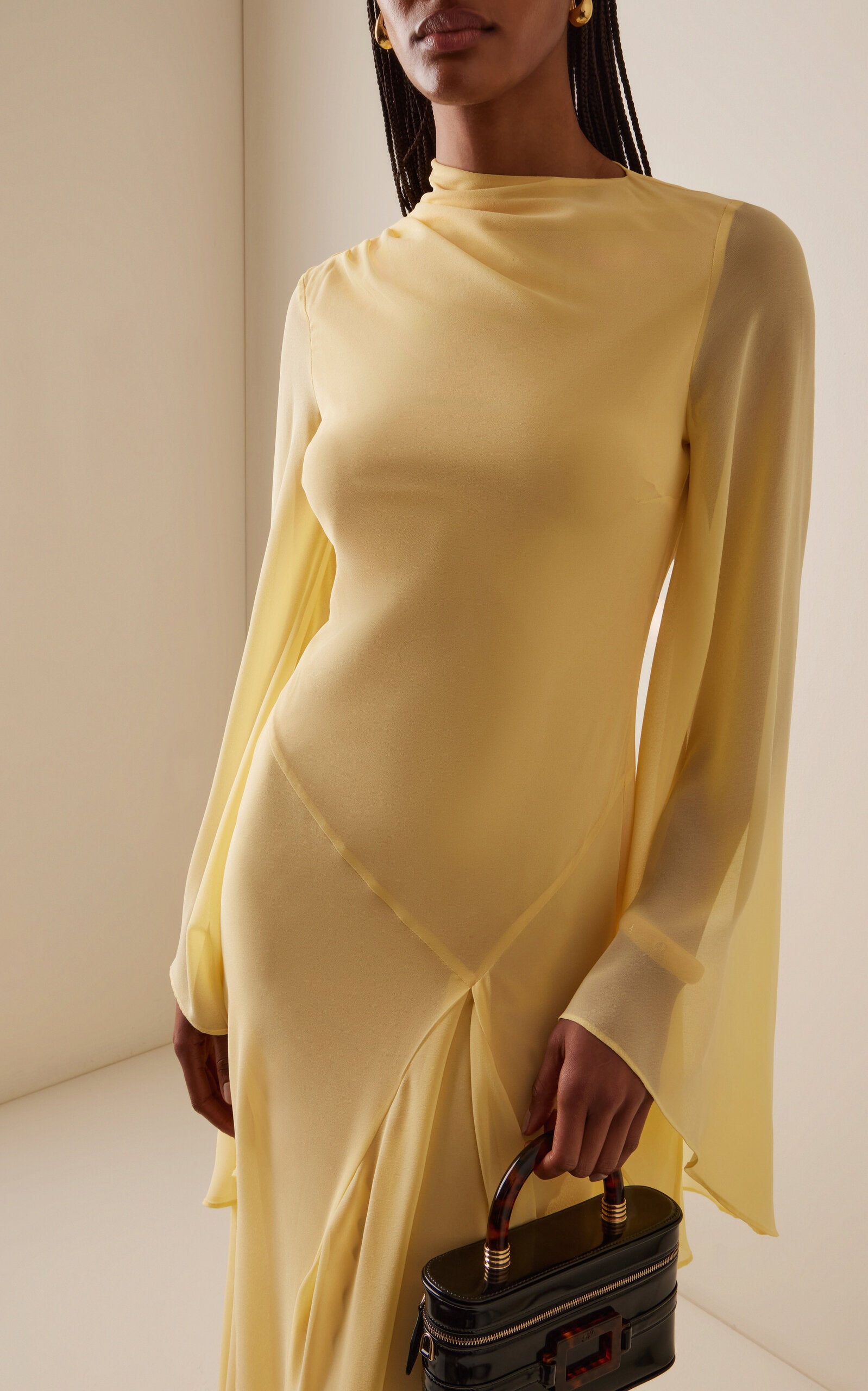 The Hausos Chiffon Maxi Dress by De La Vali features a graceful ankle-to-floor length with a dipped waist seam that enhances your natural silhouette. Its draped skirt with godet adds movement and flow, while the asymmetric neckline offers a unique touch. Long pagoda sleeves create a dramatic flare, combining elegance with a bold statement. Designed to make you feel confident and effortlessly empowered in every occasion.