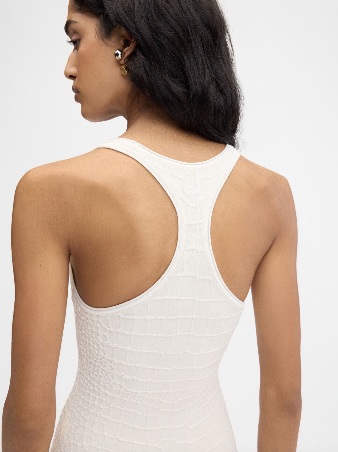 The Scala dress by Jacquemus combines elegance and edge with its long, fitted silhouette crafted from crocodile-embossed stretch viscose. Its square neckline and sleeveless racerback design enhance your natural shape while offering comfort and style. A long back slit adds a daring touch, and the subtle “J” locker loop detail sets this dress apart. Perfect for making a bold statement at any event.