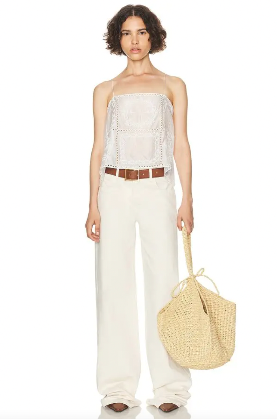 Introducing the Handkerchief Camisole by Helsa, crafted from luxurious linen and adorned with delicate eyelets and embroidered florals. The shoulder strap tie closures and side slits add a touch of sophistication. Perfect for warm weather, this garment is purposefully sheer, adding an alluring touch. Don't be afraid to let your undergarments peek through. Elevate your wardrobe with this elegant piece.