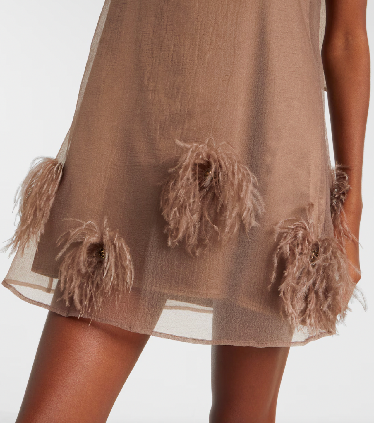 The Albee Feather-trimmed Minidress by Staud is your ticket to turning heads at any upscale occasion. This semi-sheer design combines sophistication with undeniable allure, featuring a flattering high neckline that frames the face beautifully. Luxurious feather trims add an unexpected glamorous edge, elevating the piece from elegant to extraordinary. 